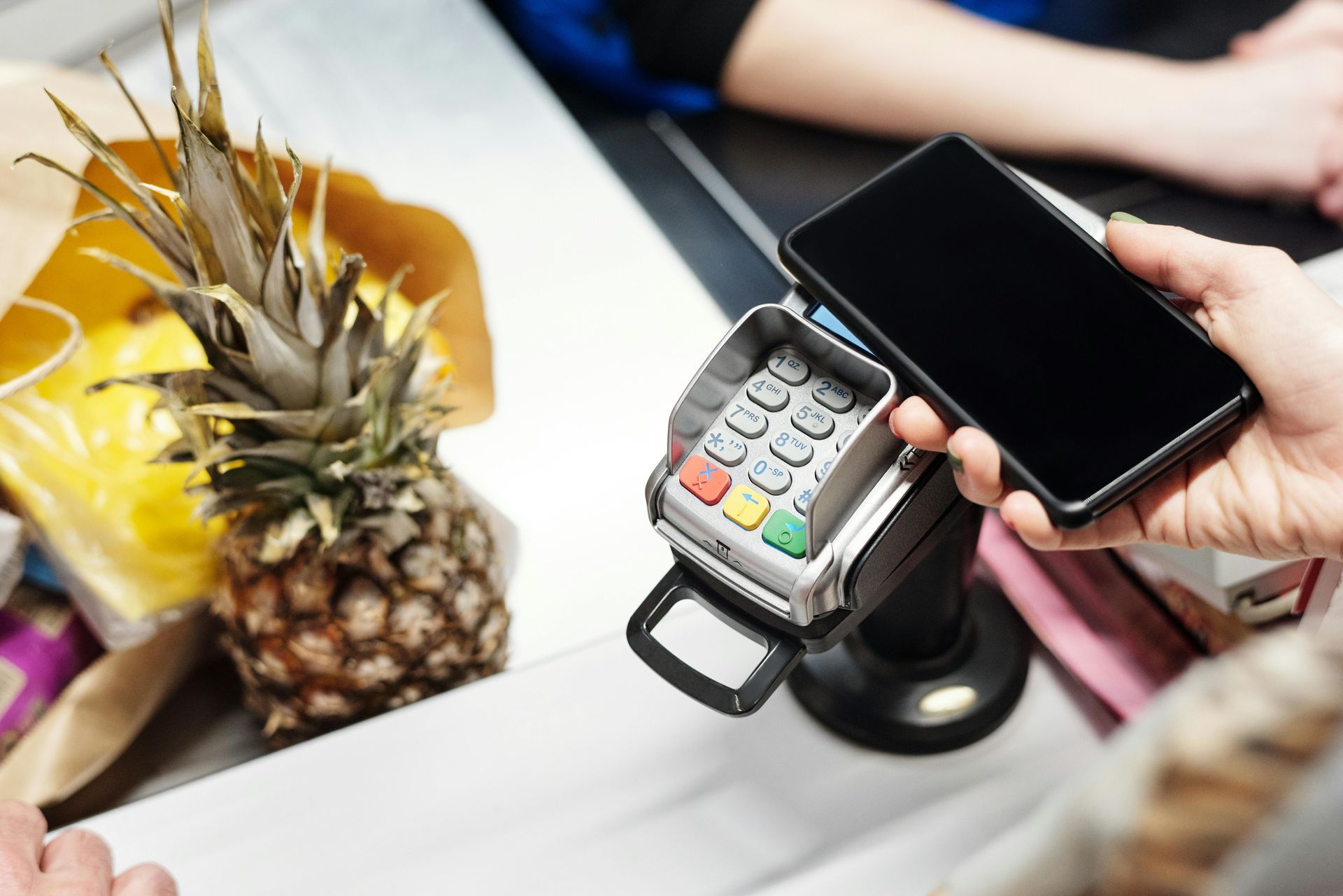 A person is using a cell phone to pay for groceries.