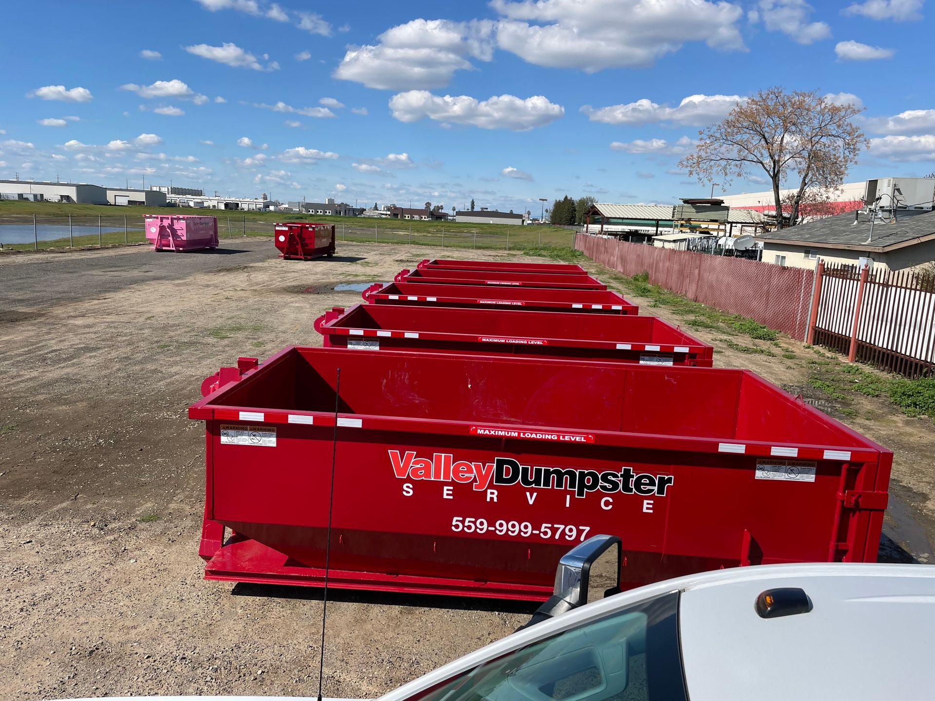Valley Dumpster Service delivery — red dumpster placed on residential driveway in Fresno