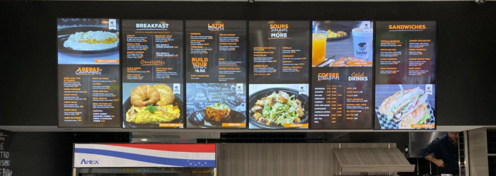 a restaurant with a large screen displaying a Digital menu.