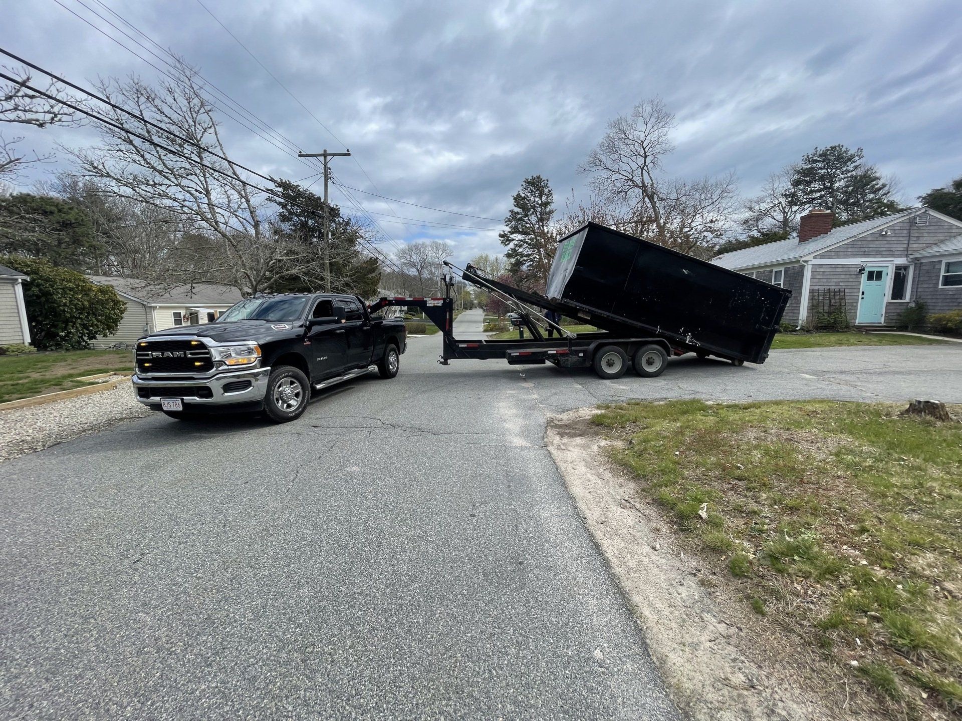 Dumpster offloaded from trailer onto a driveway