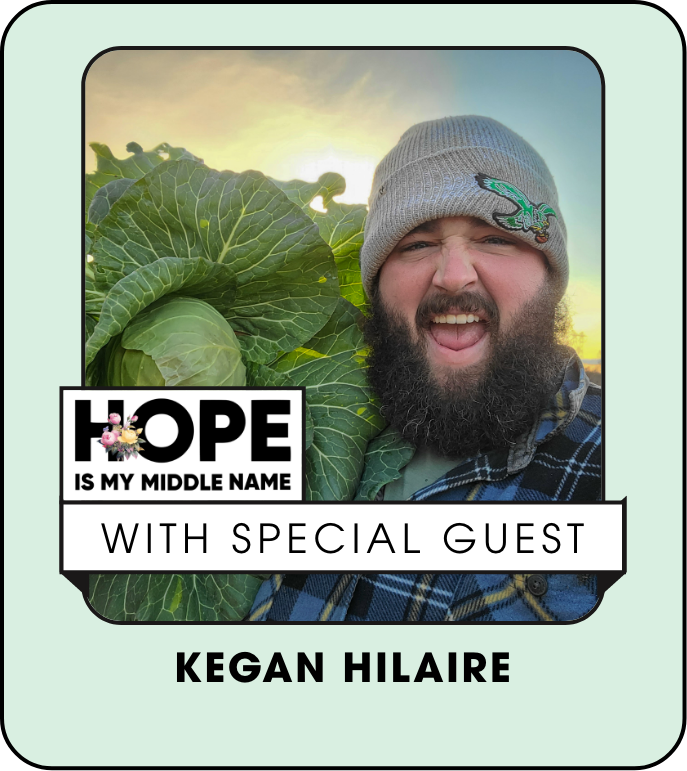 A man with a beard is standing in front of a cabbage.