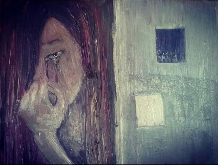 A painting of a woman crying on a wall.