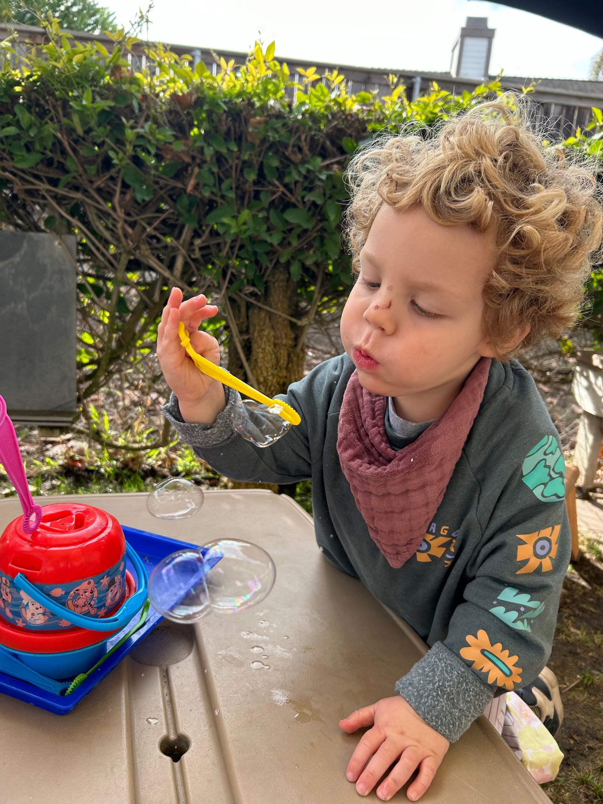 Montessori child blowing bubbles.