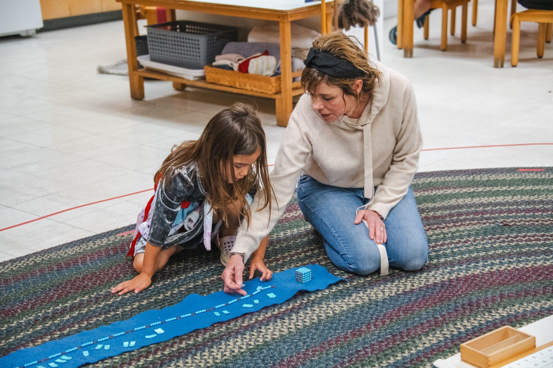 Montessori children and guide working with math materials.