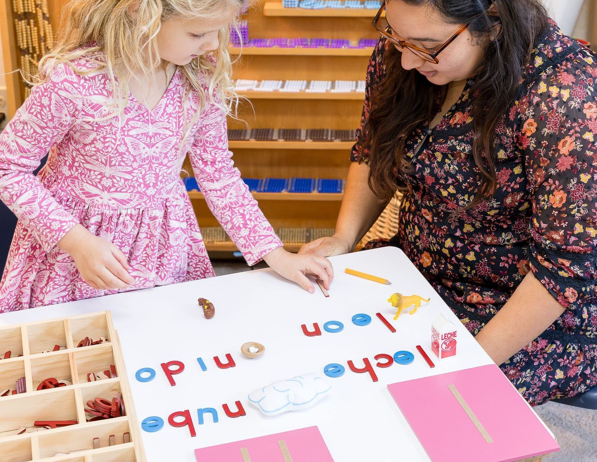 Guide and child working on Spanish vocabulary Montessori with language materials.