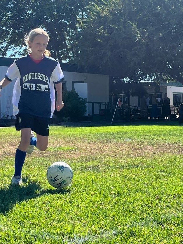 Montessori child playing soccer.