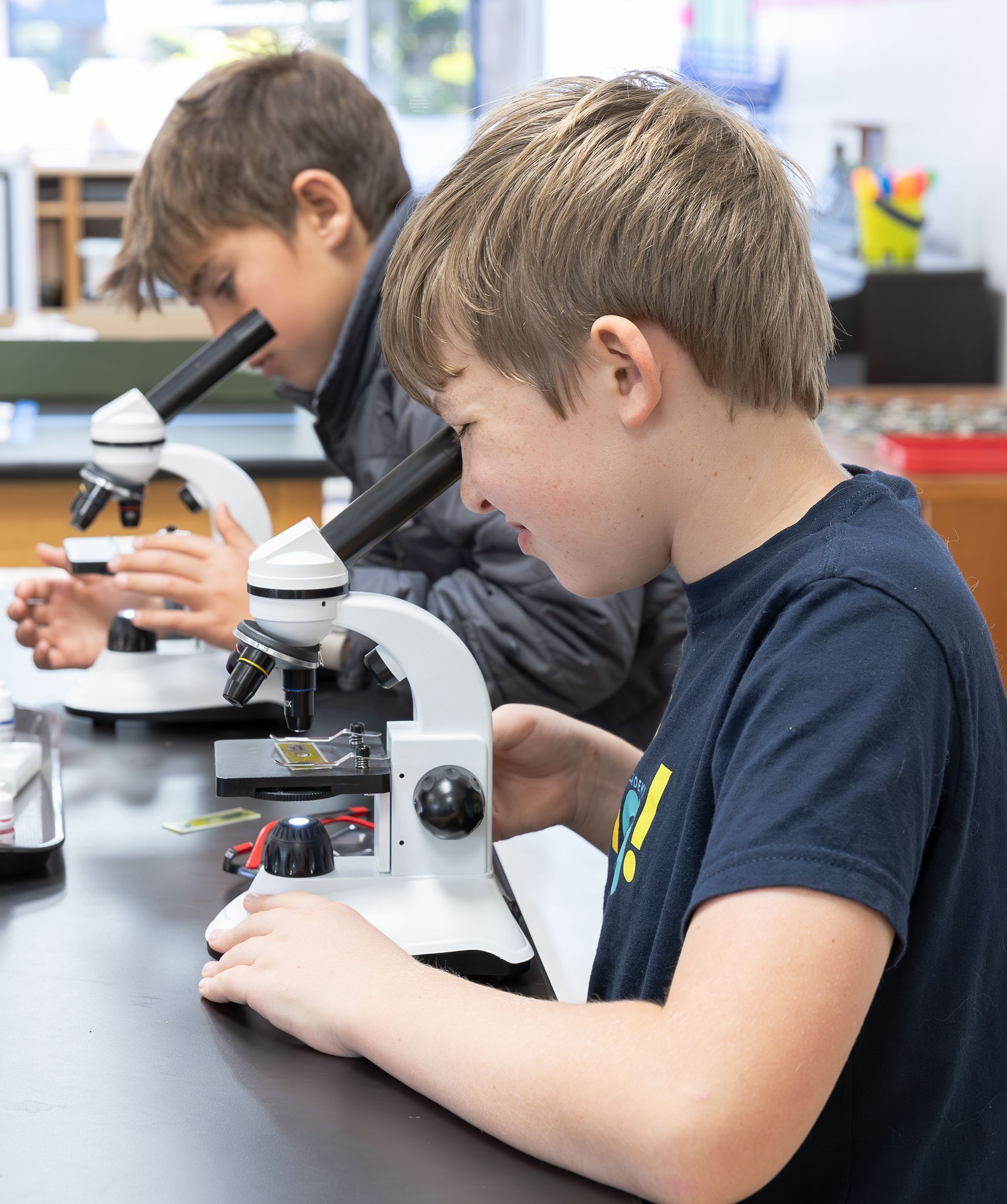 Montessori children looking into microscopes.