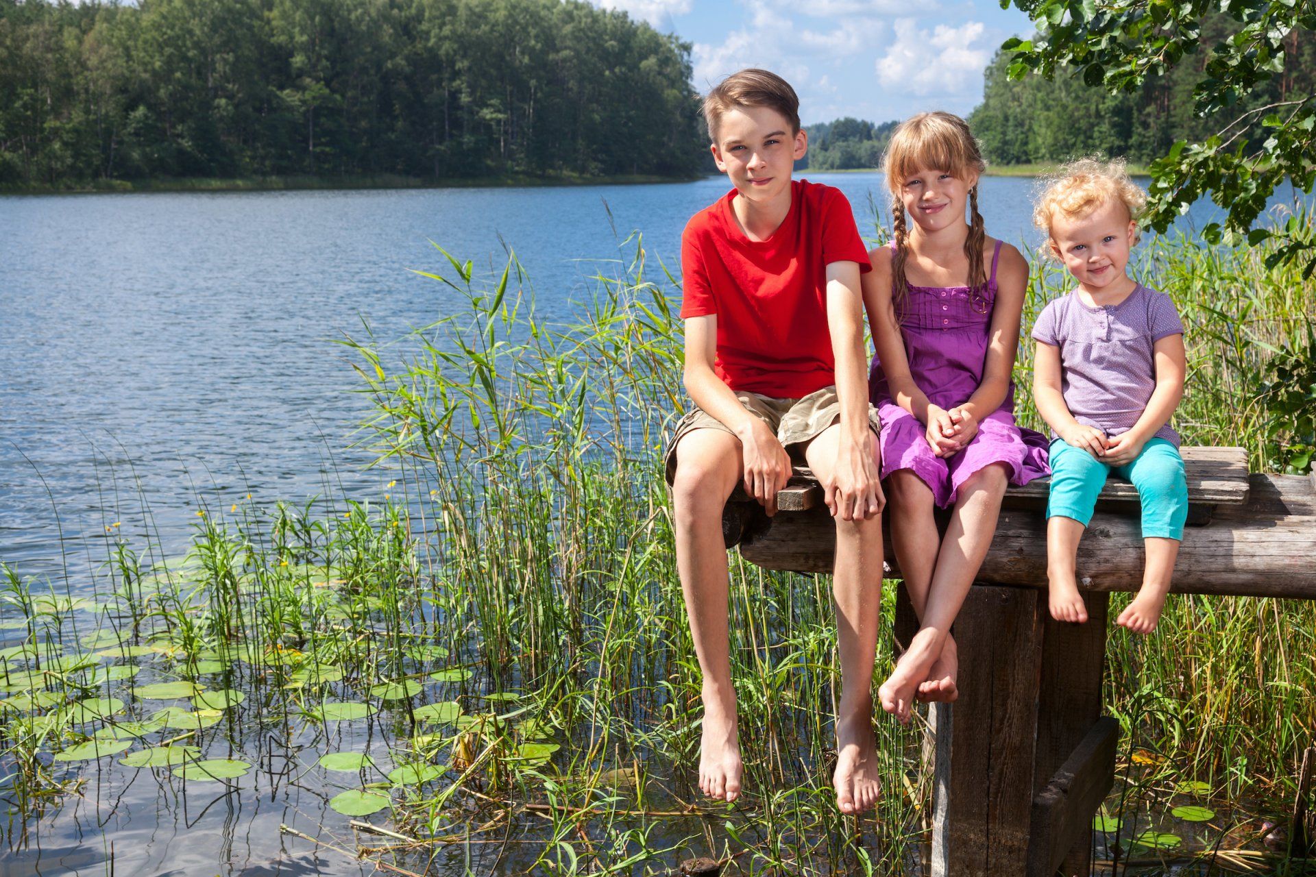 Montessori children of different ages seating on a dock