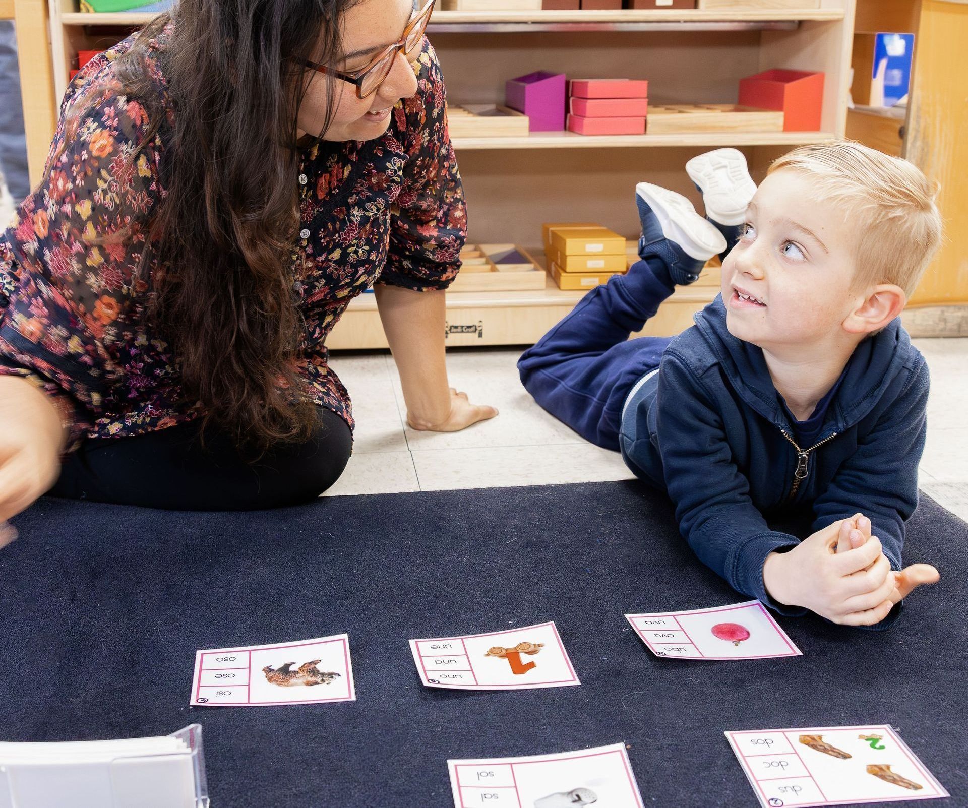 A guide and a child are working with montessori language materials