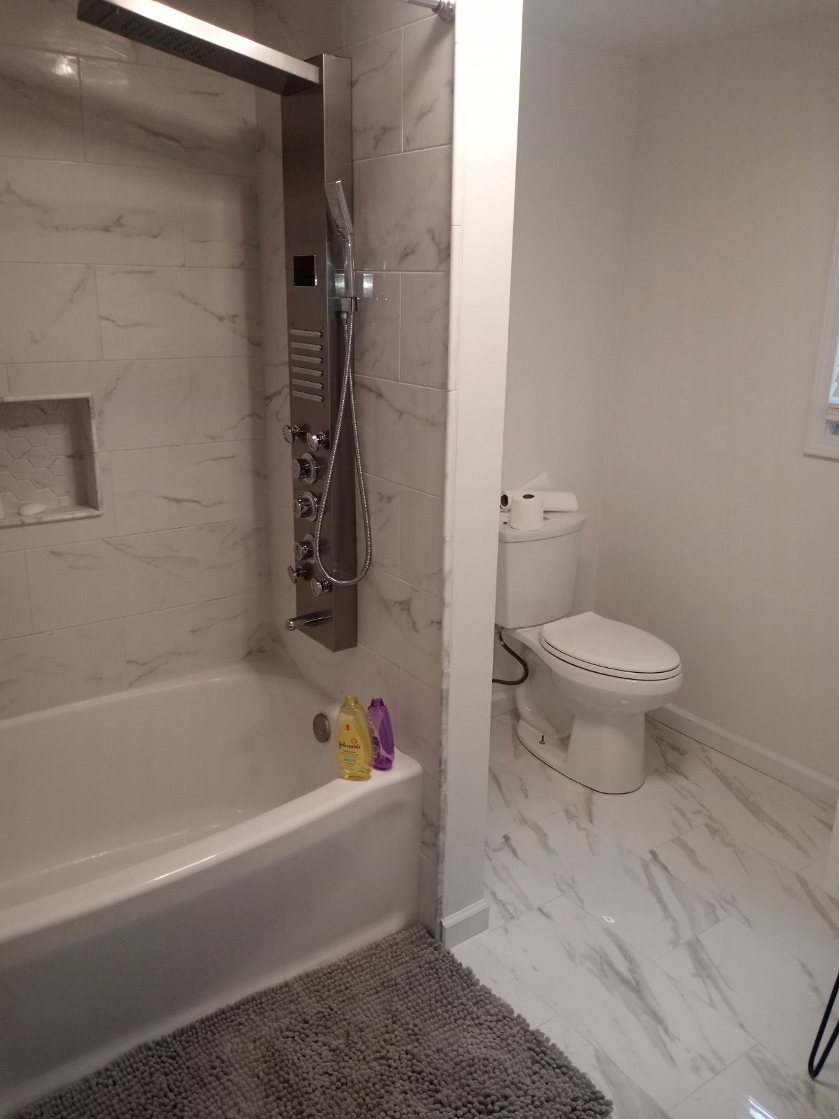 A bathroom with a tub , toilet and shower.