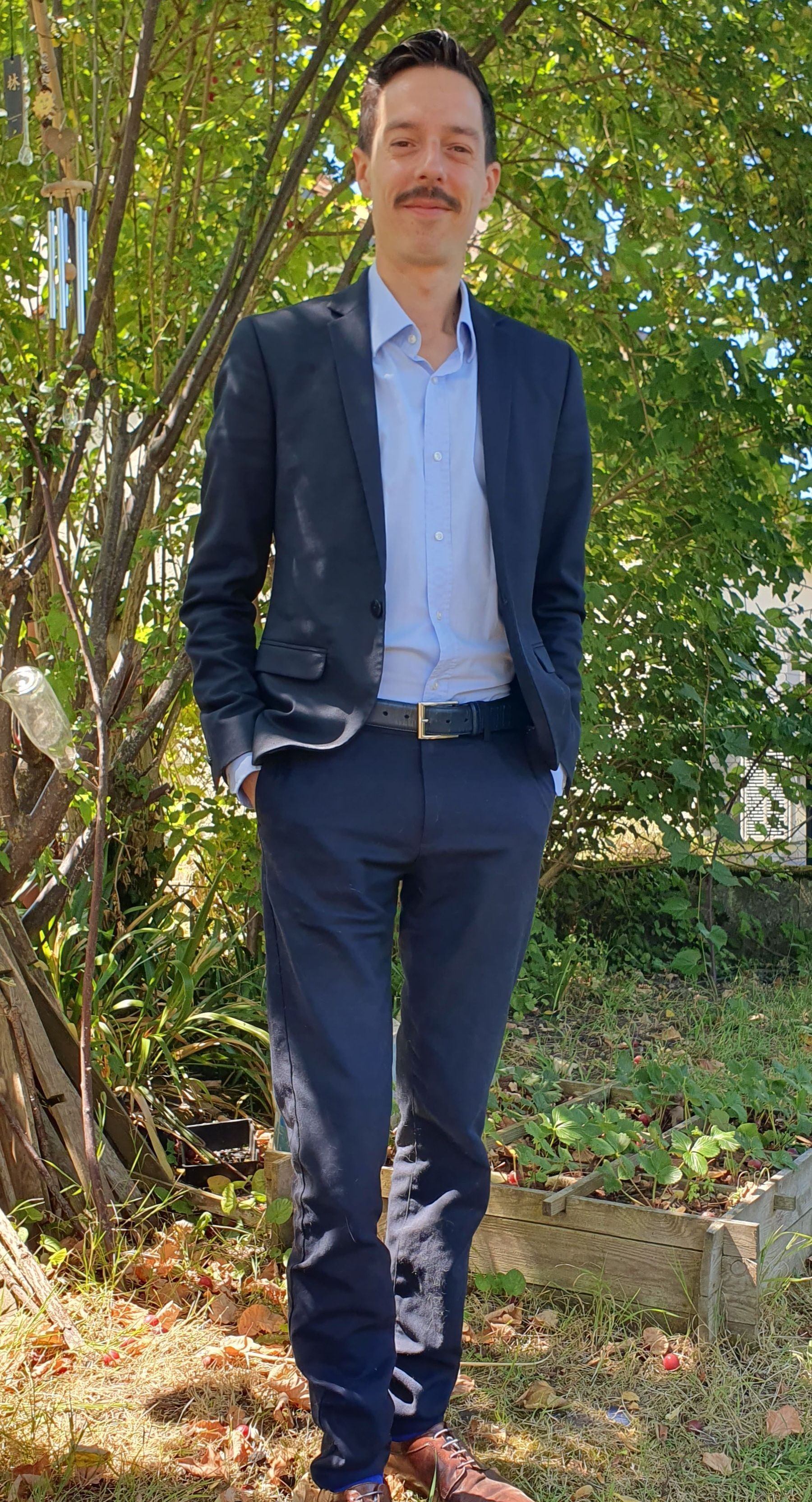 Fabien COQUELET, Co fondateur, DG et transporteur de traction, en costume bleu, chemise bleu posant dans un jardin