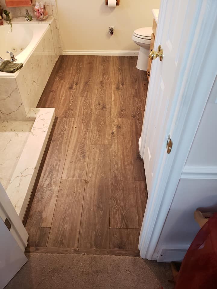 A bathroom with a wooden floor and a toilet.