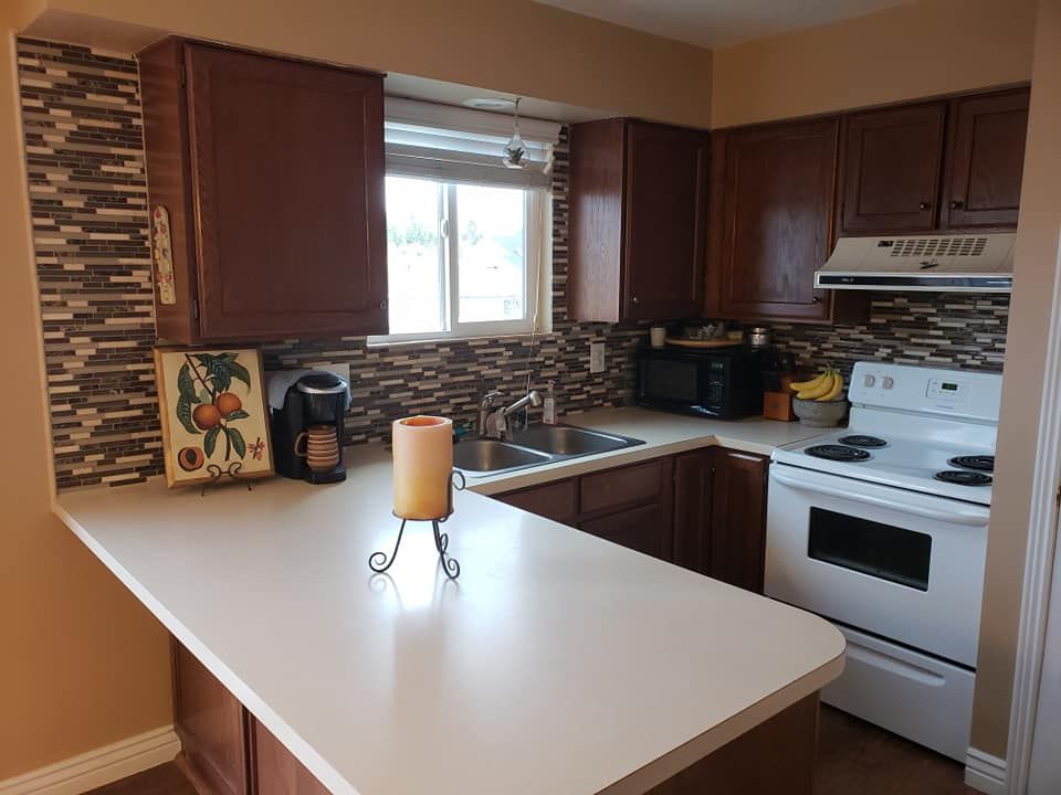 A kitchen with wooden cabinets and a white stove