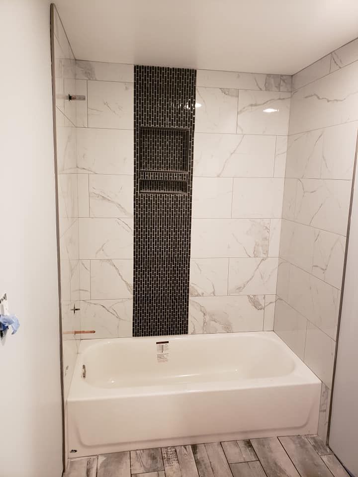 A bathroom with a bathtub and a shower.