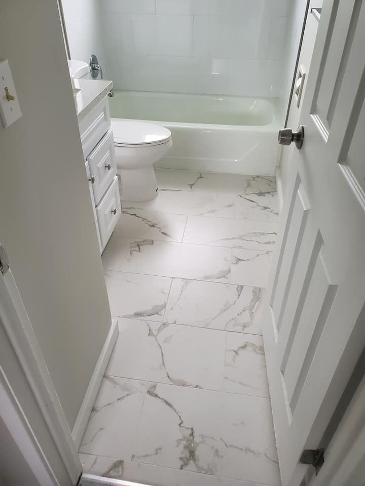 A bathroom with a toilet , sink , and bathtub.