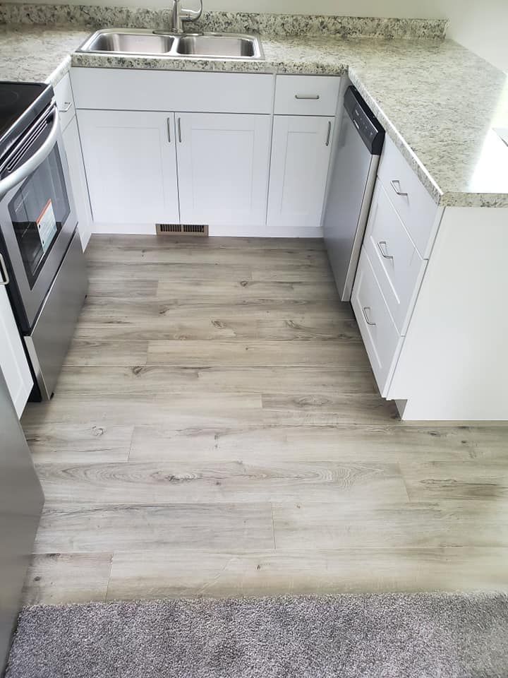 A kitchen with a sink , stove , and dishwasher.