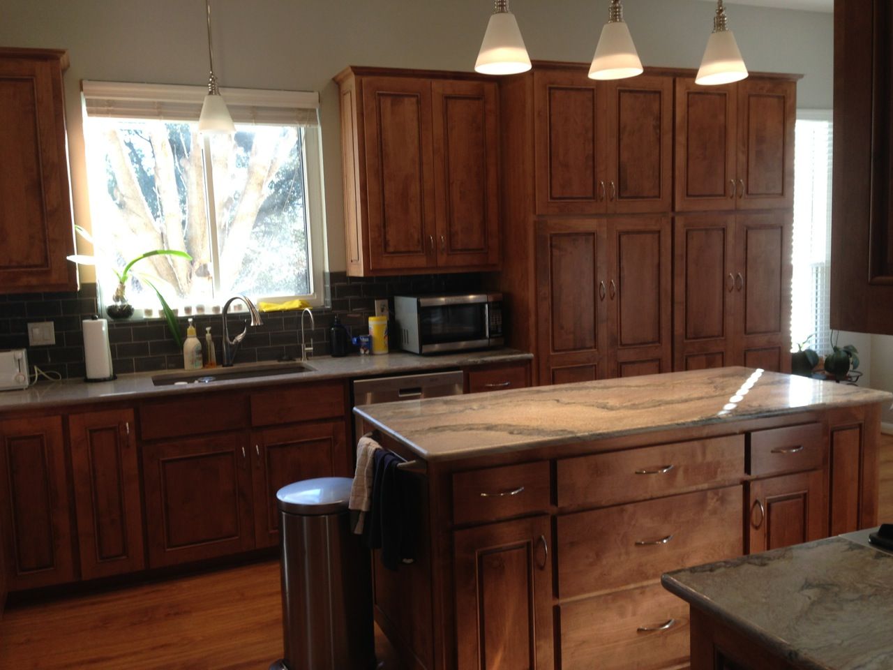 A kitchen with wooden cabinets and a large island