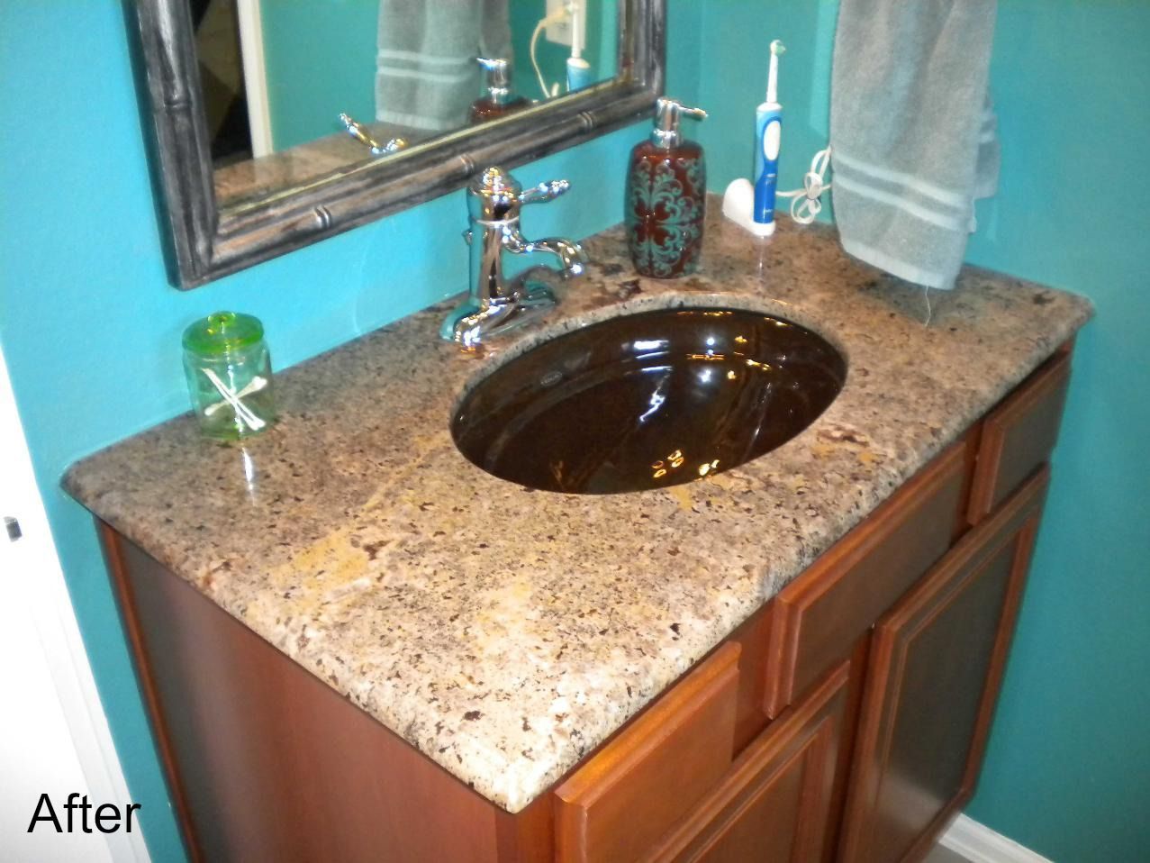 A bathroom sink with a granite counter top and a mirror