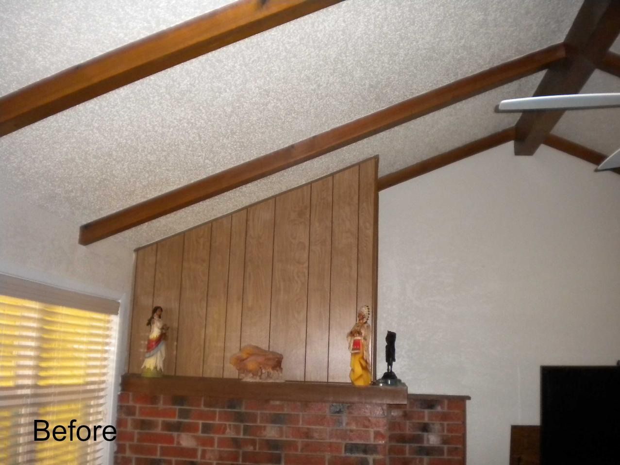 A before picture of a living room with a brick fireplace