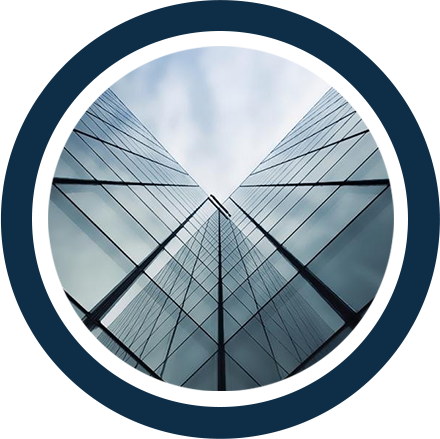 Due alti grattacieli di vetro che si incontrano in un punto, visti dal basso.