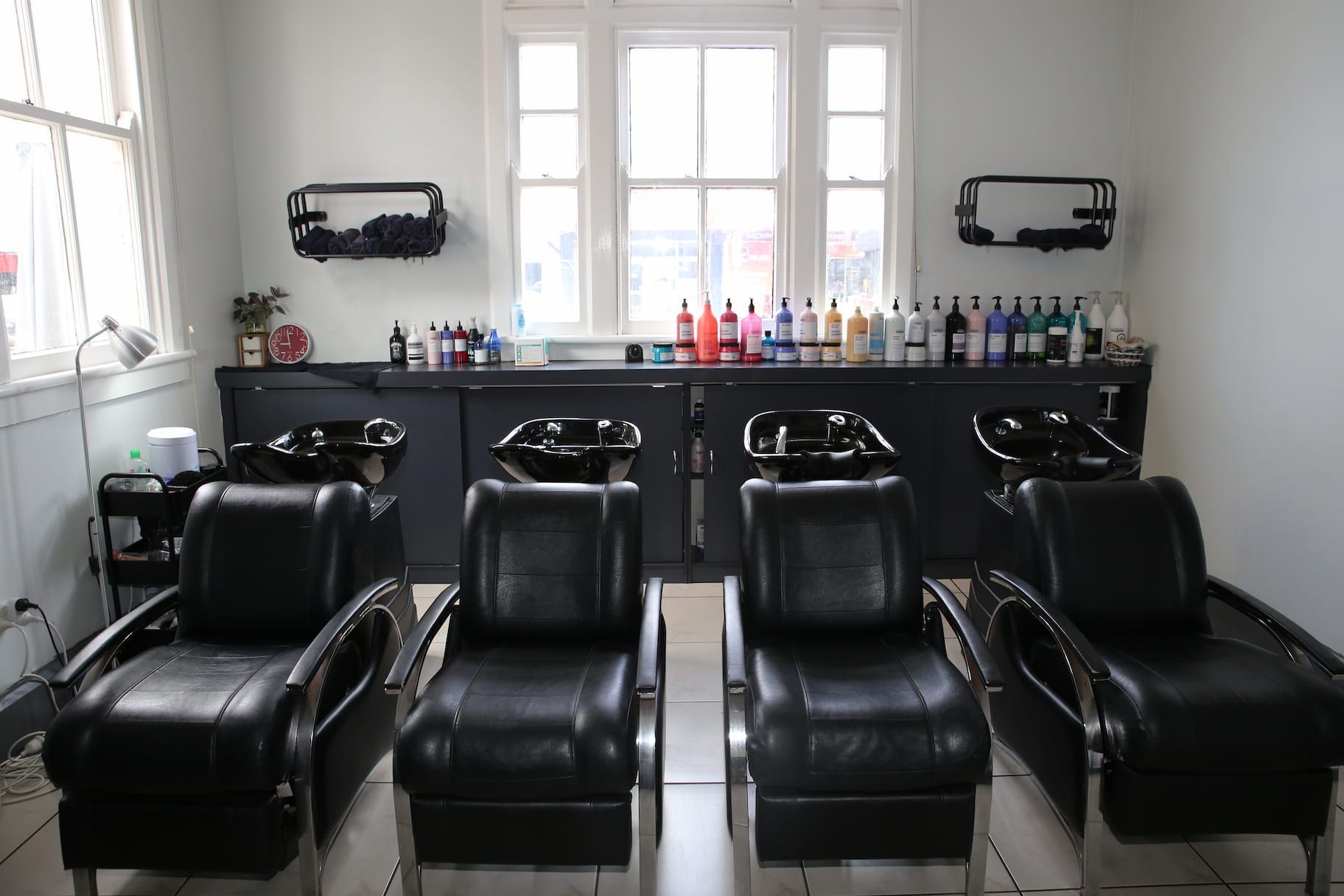 a row of black chairs in a hair salon
