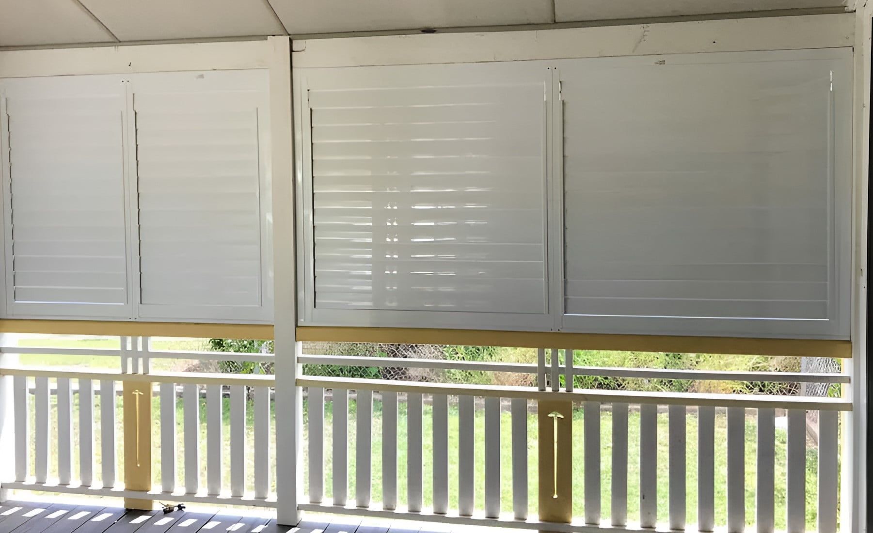 A Porch With White Shutters On The Windows And A Yellow Railing — Advantage Screens and Blinds Hervey Bay In Pialba, QLD