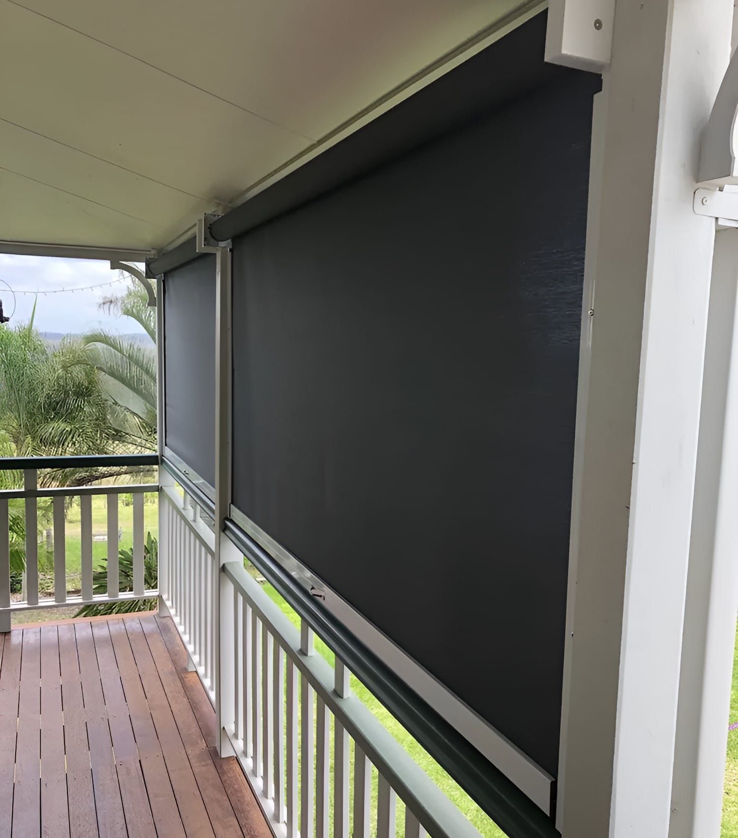A Porch With A White Railing And Black Blinds On It — Advantage Screens and Blinds Hervey Bay In Pialba, QLD