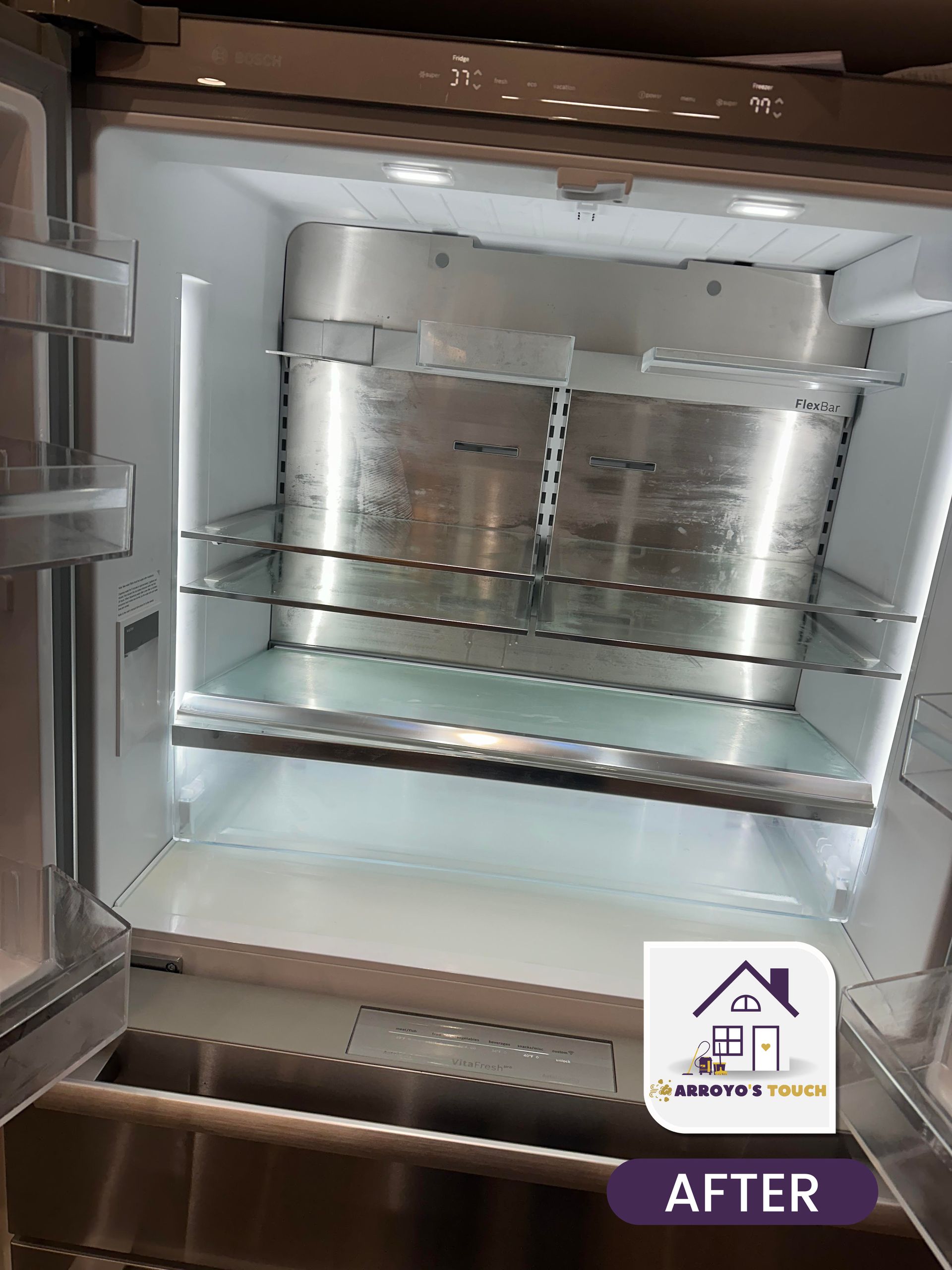 Inside of a cleaned stainless steel refrigerator; glass shelves, bright interior lighting, 