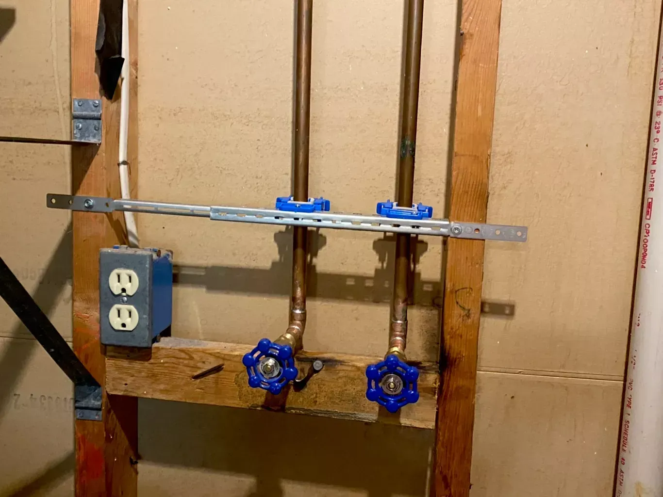 A wooden frame with pipes and valves attached to it.