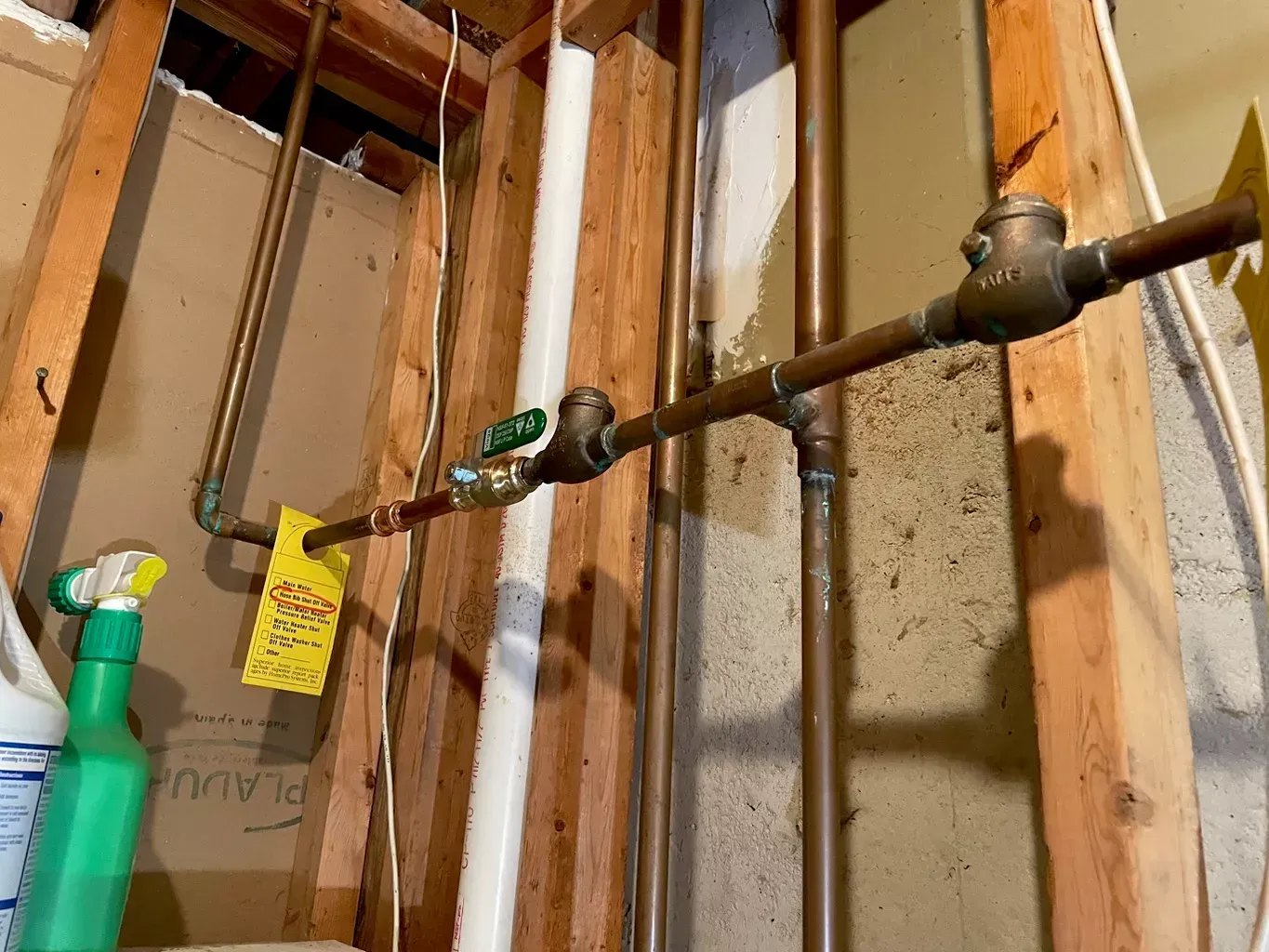 A room with a lot of pipes and a spray bottle