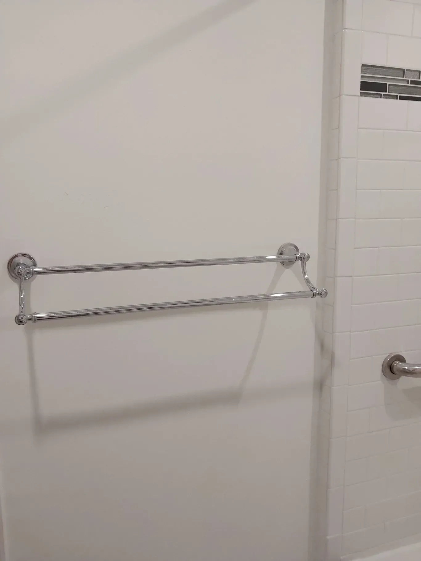 A towel rack is hanging on a white wall in a bathroom.