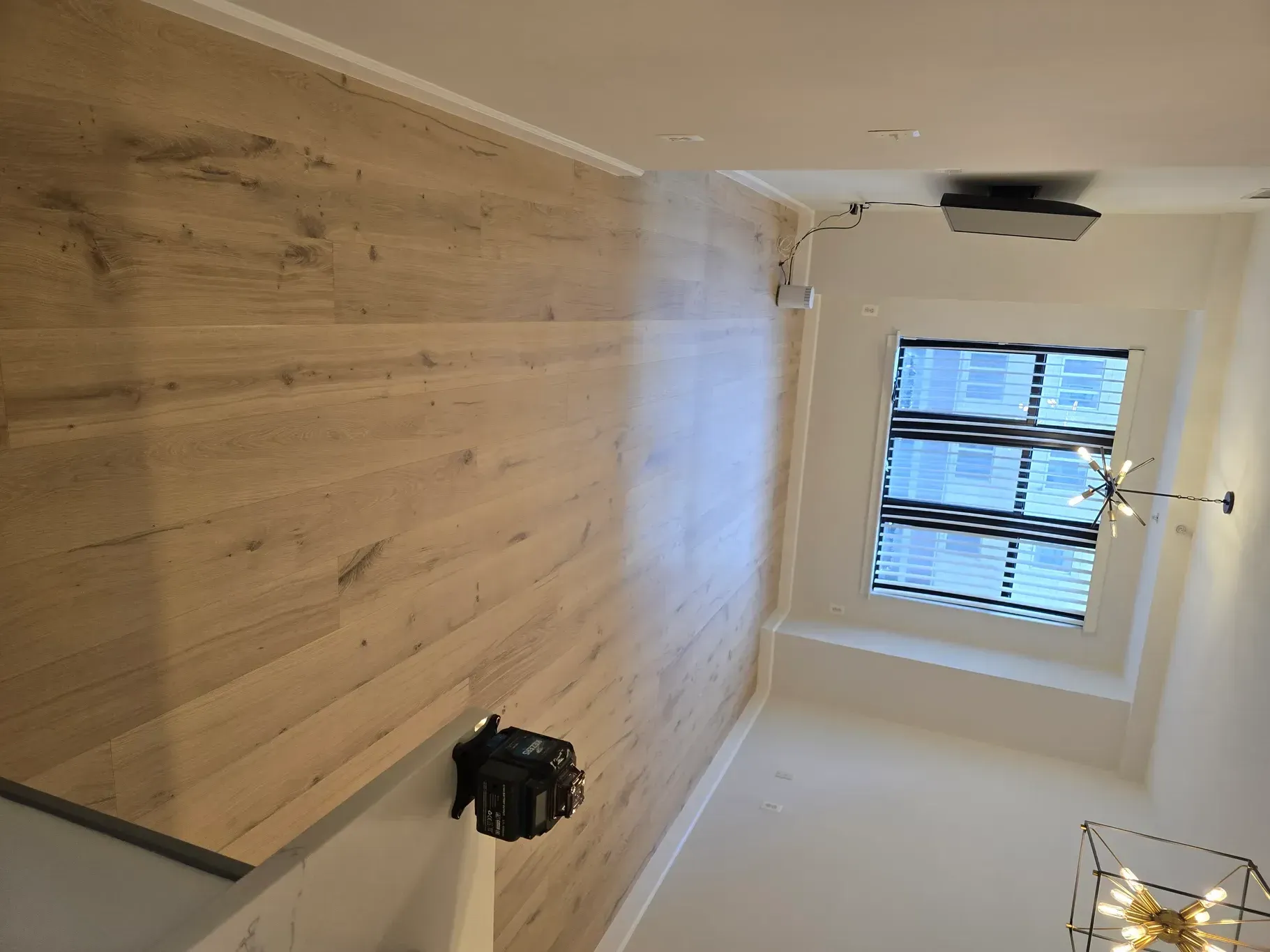 A room with a wooden wall and a window.