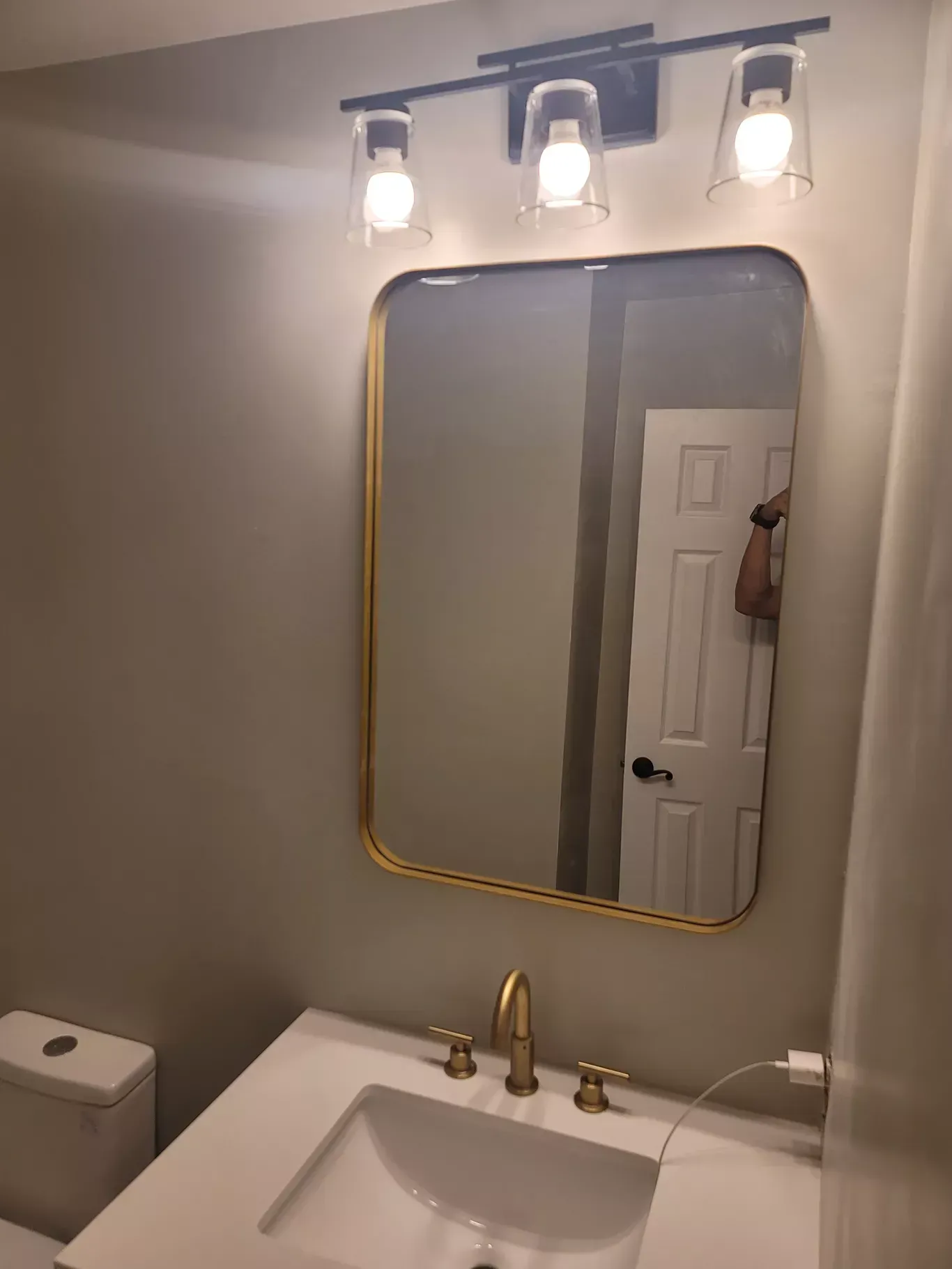 A bathroom with a sink , toilet and mirror.