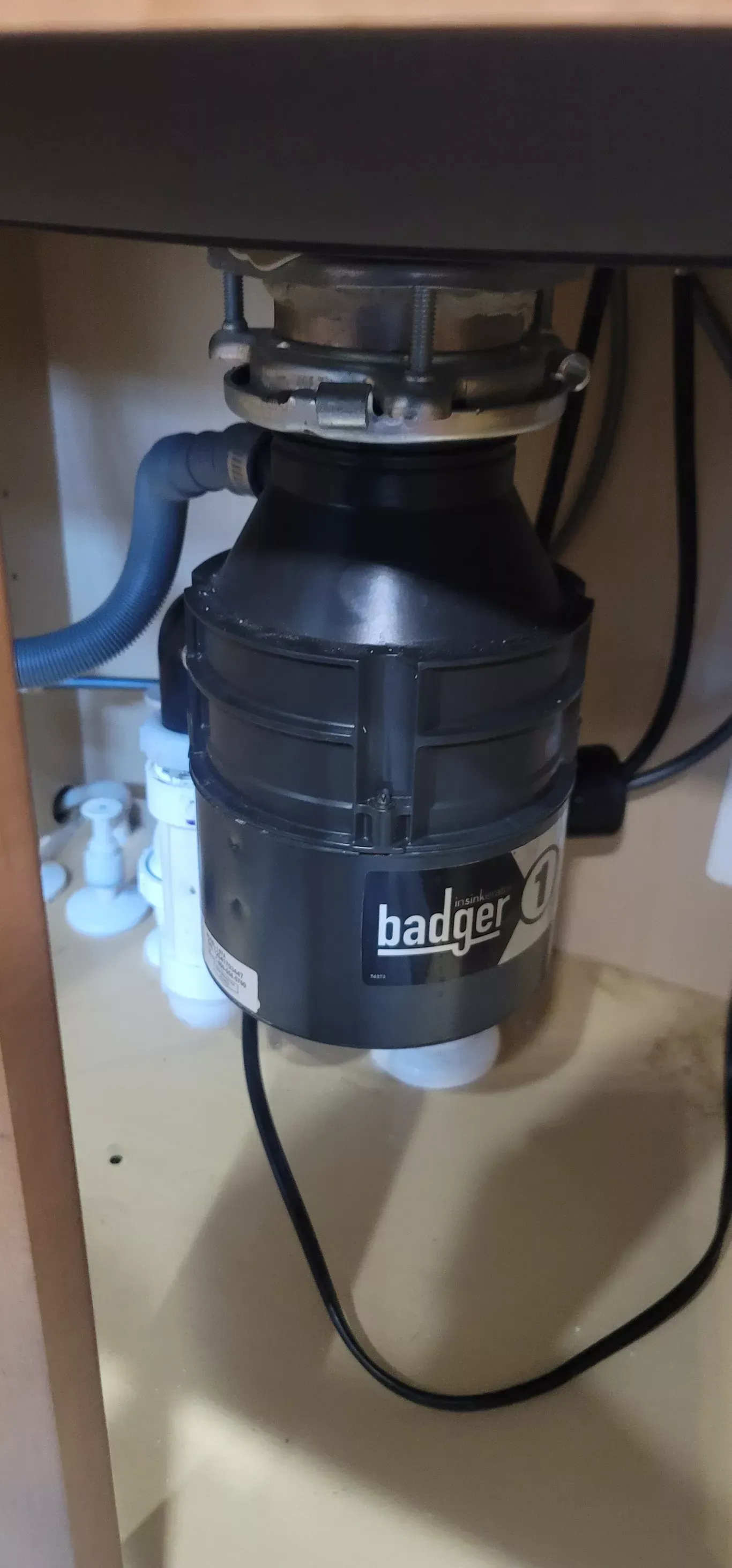 A garbage disposal is sitting under a sink in a kitchen.