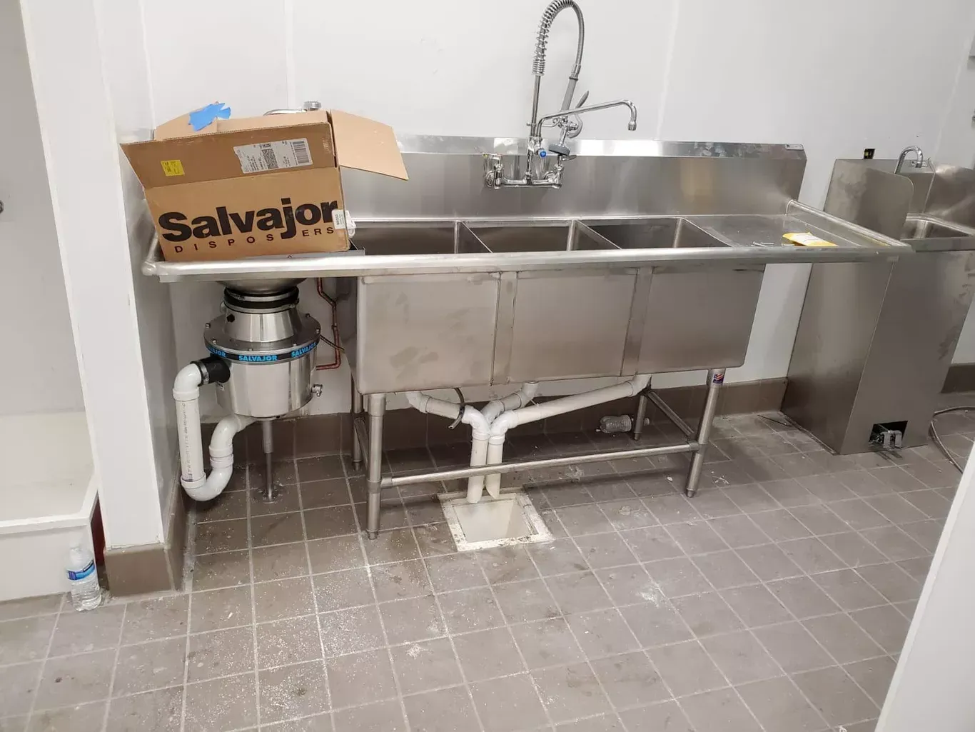 A stainless steel kitchen sink with a box on top of it.