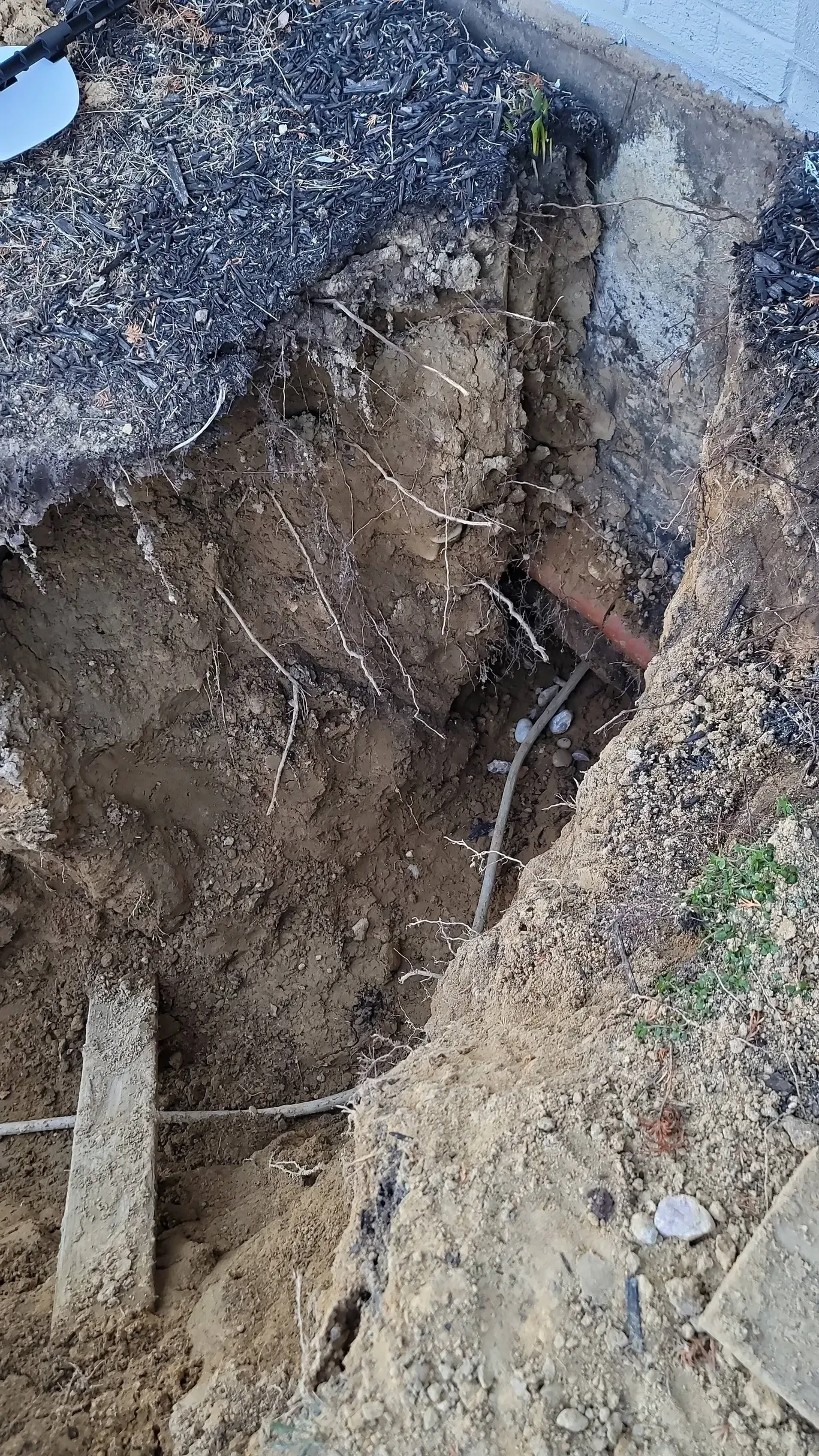 A hole in the ground with a pipe coming out of it.