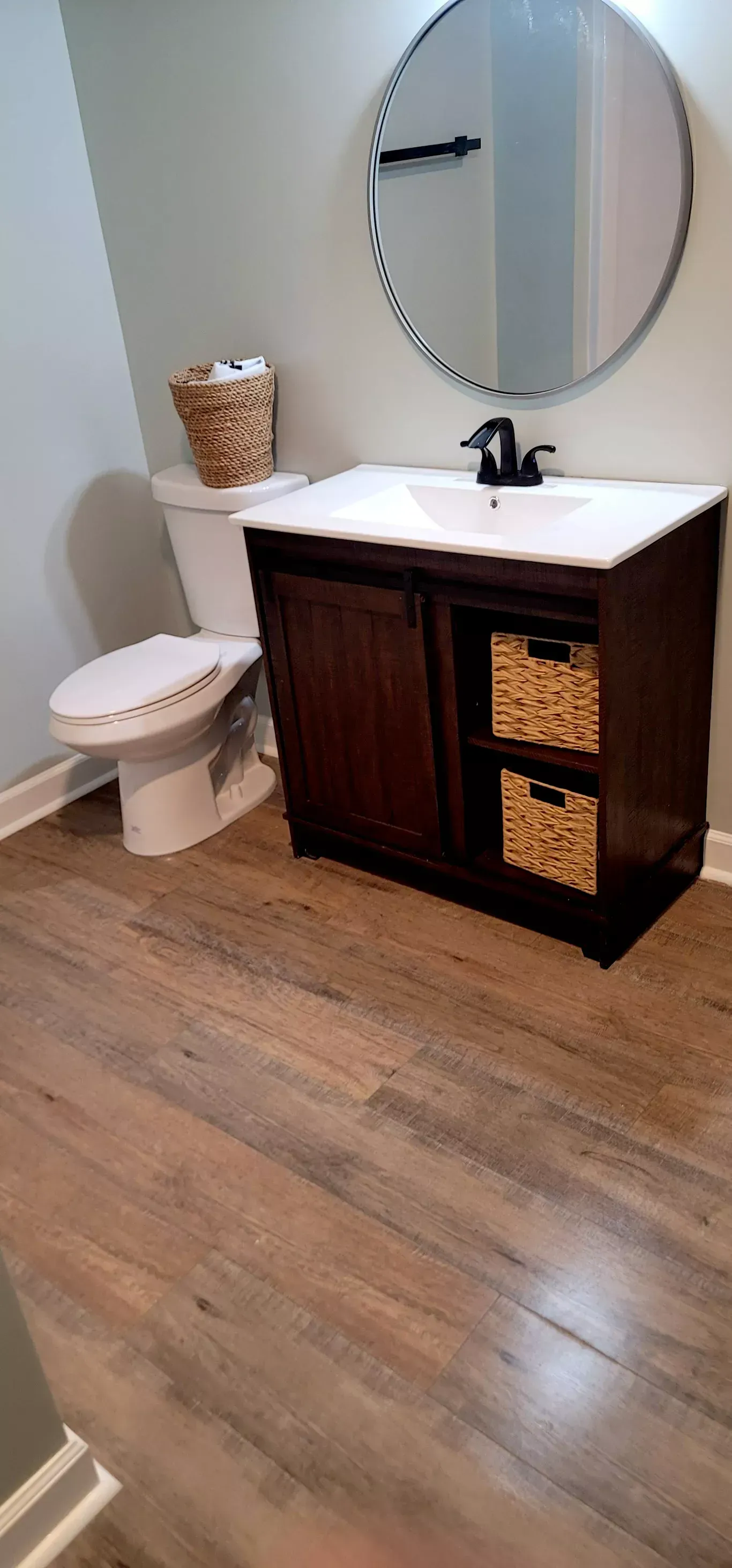 A bathroom with a toilet , sink , and mirror.