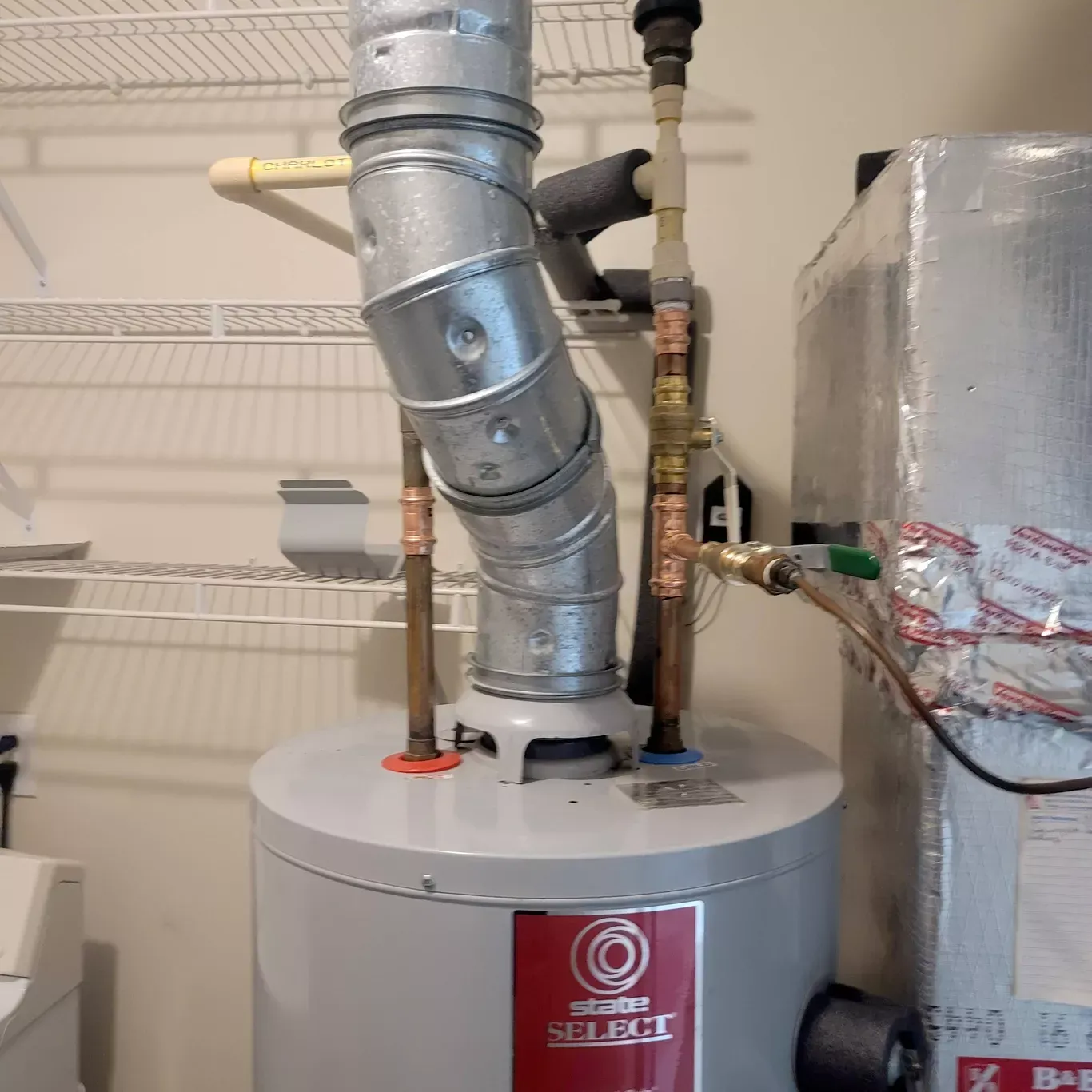 A silver water heater with a red label that says select