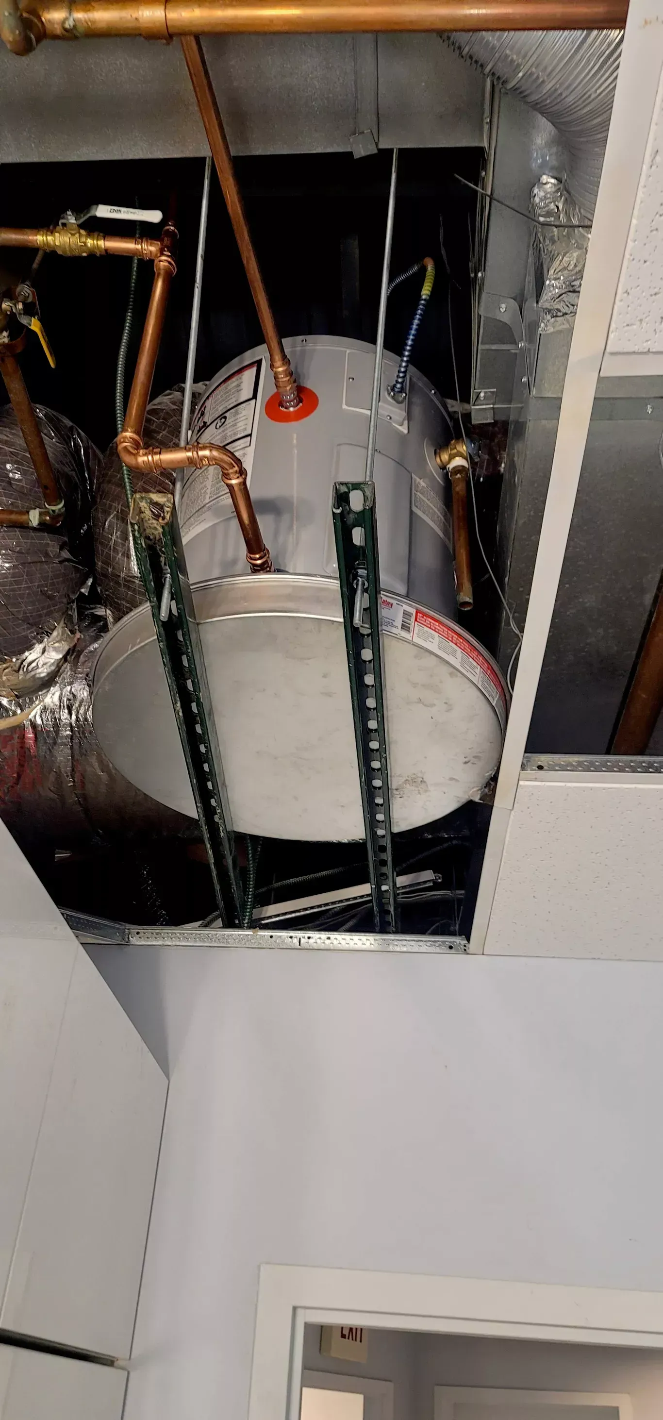 A water heater is hanging from the ceiling of a room.