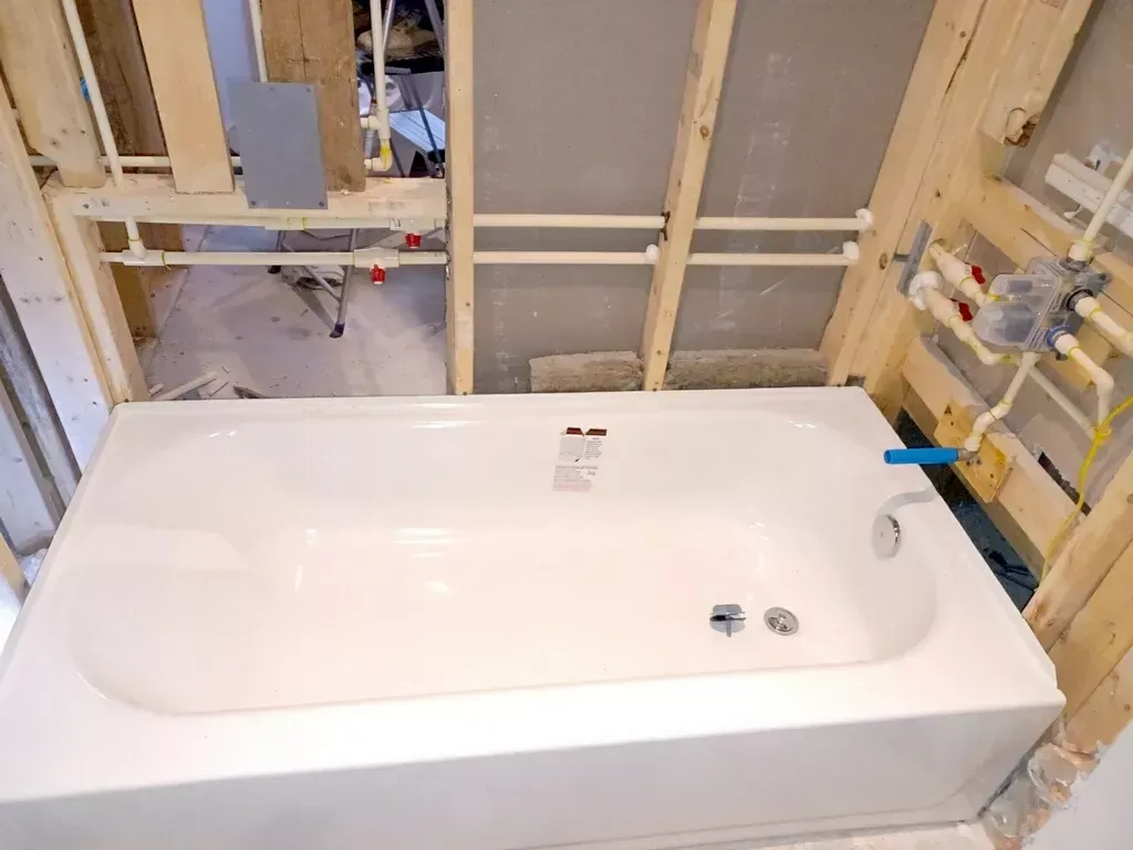 A bathtub is being installed in a bathroom under construction.