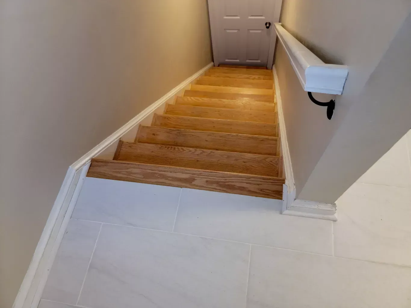 A staircase with wooden steps and a white railing
