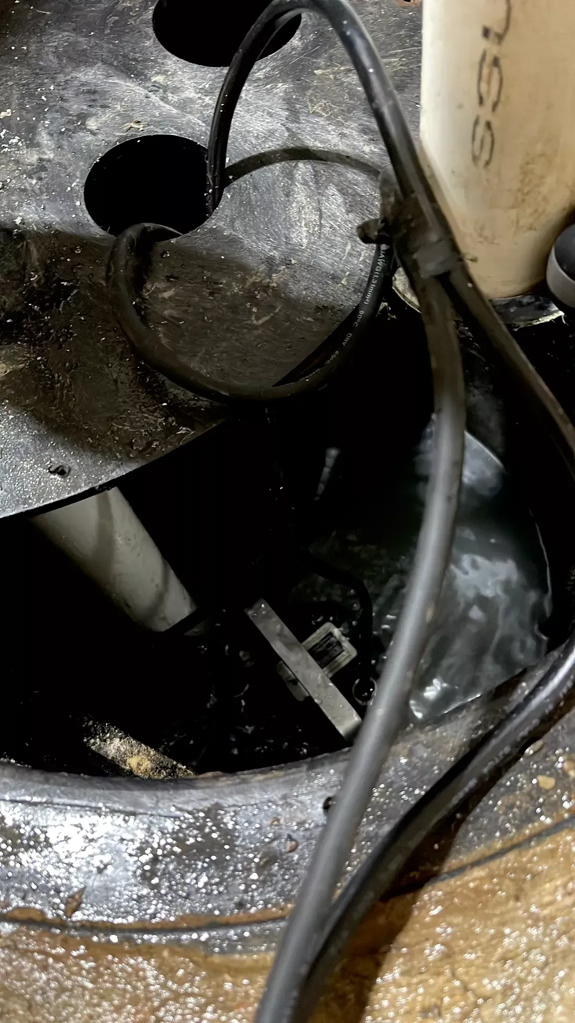 A close up of a drain with a lot of wires coming out of it.