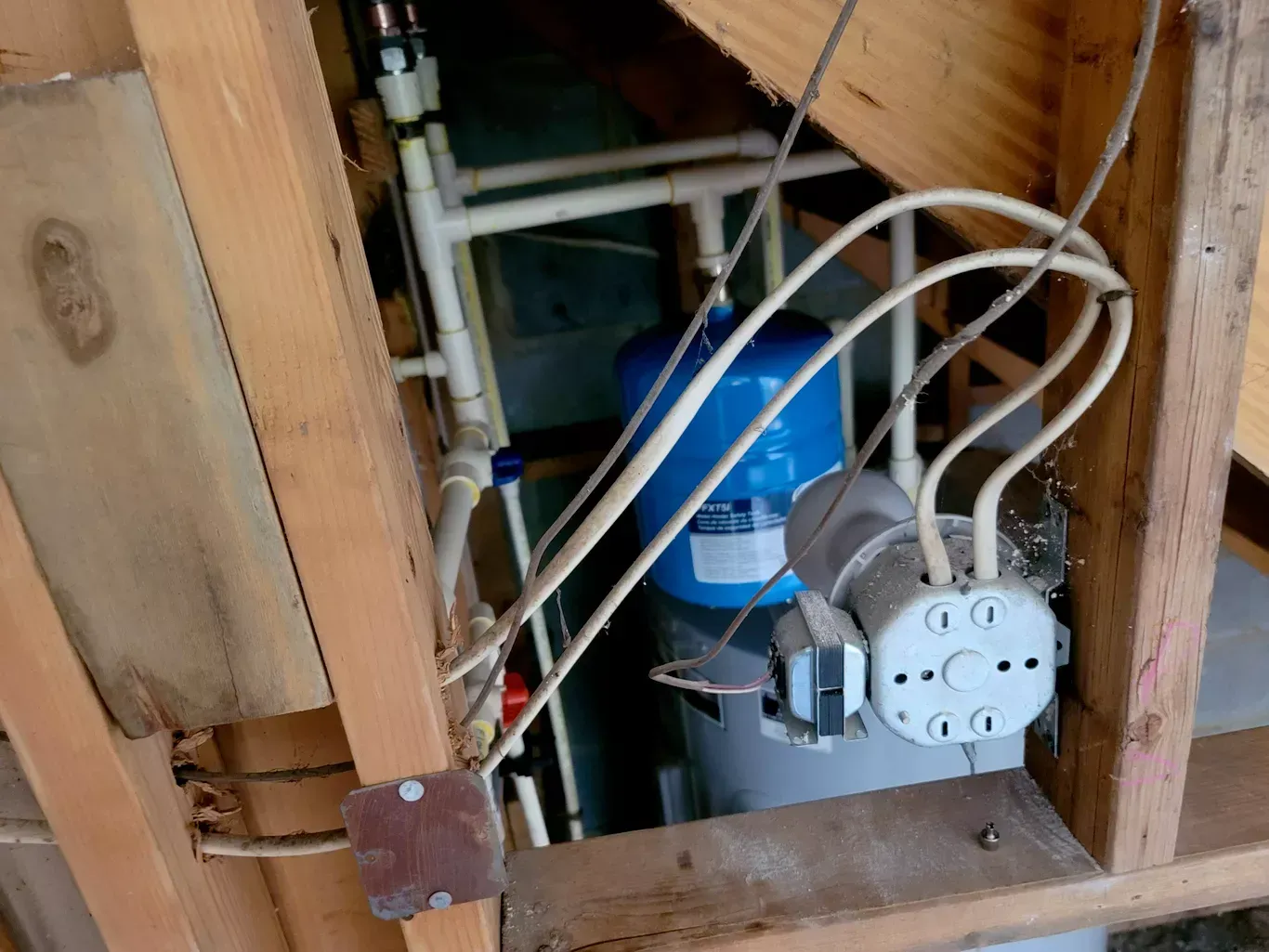 A blue water tank is attached to a wooden wall