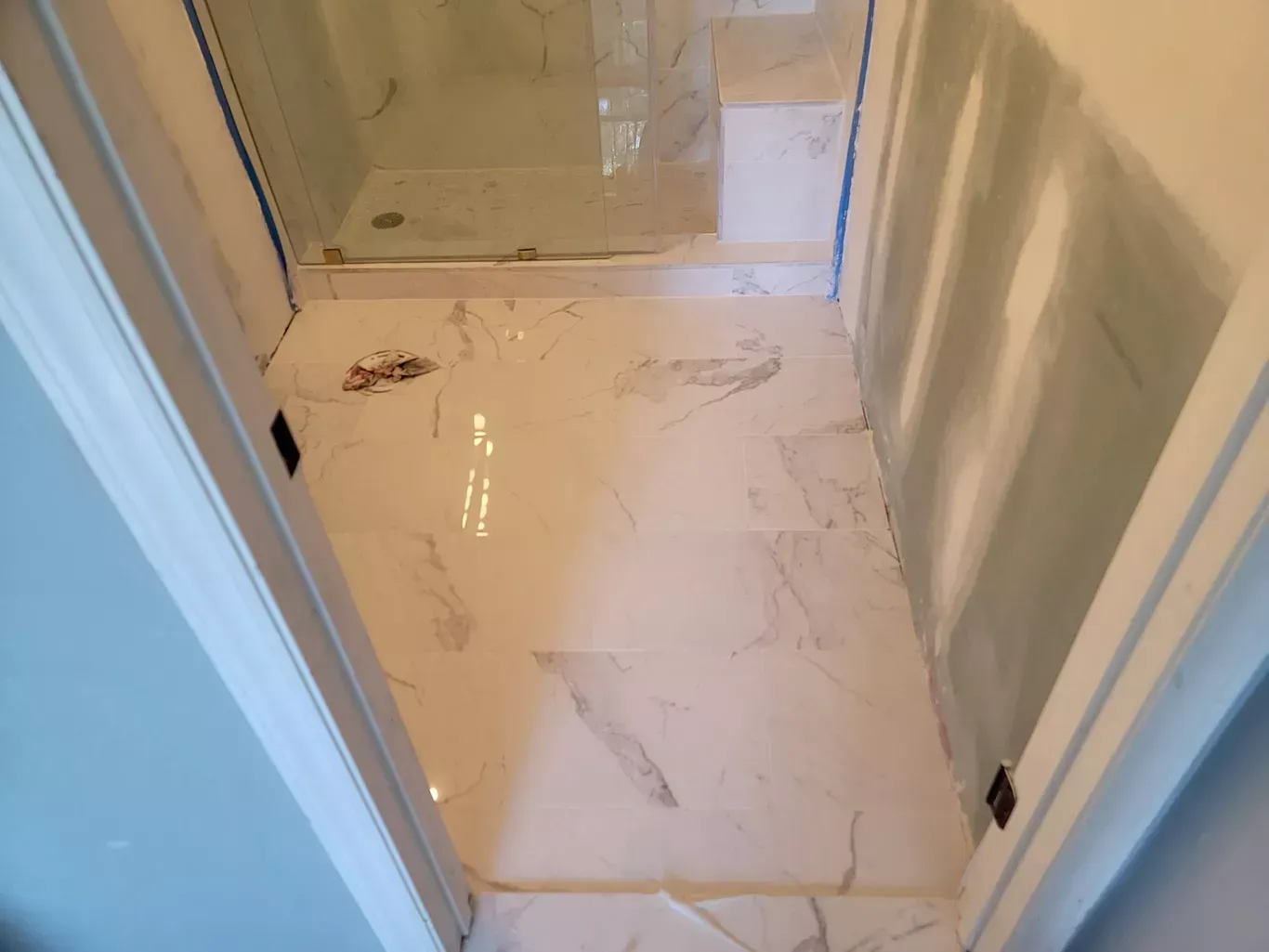 A bathroom with a marble floor and a walk in shower.