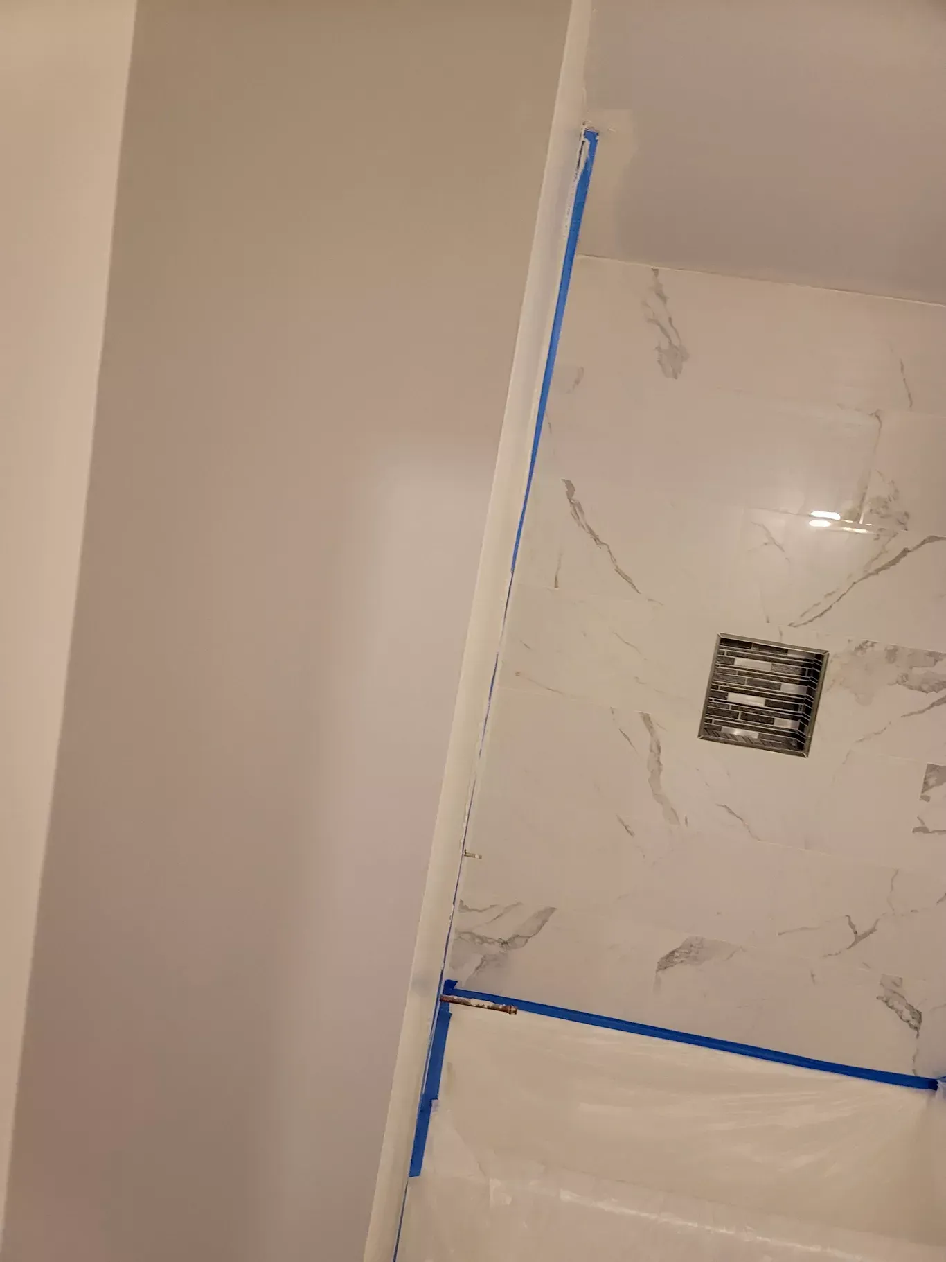 A bathroom with a marble shower and a bathtub.