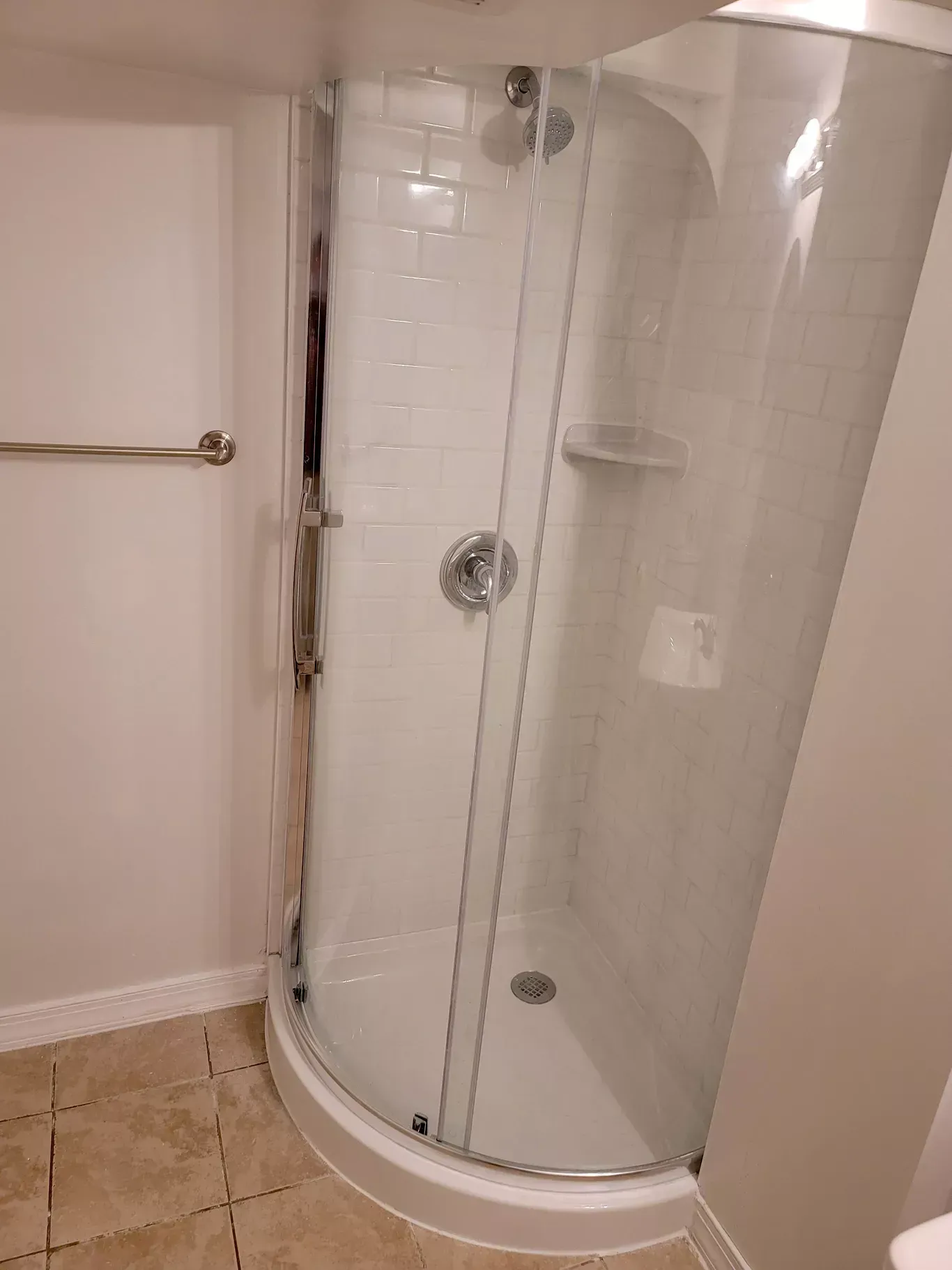 A bathroom with a shower stall and a toilet.