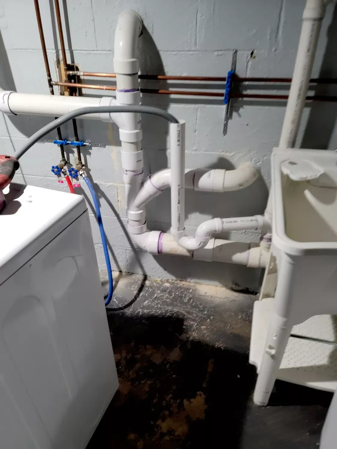 A laundry room with a washer and dryer and a sink