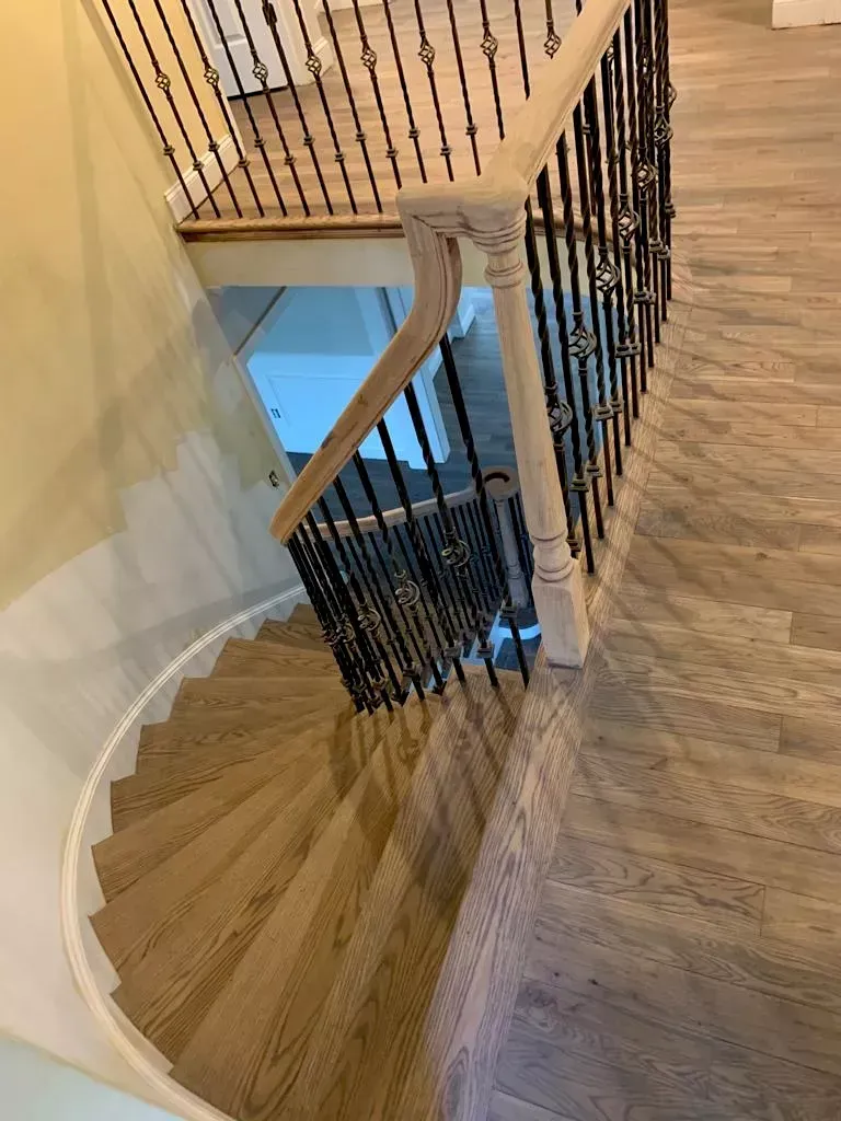A spiral staircase with a wrought iron railing in a house.