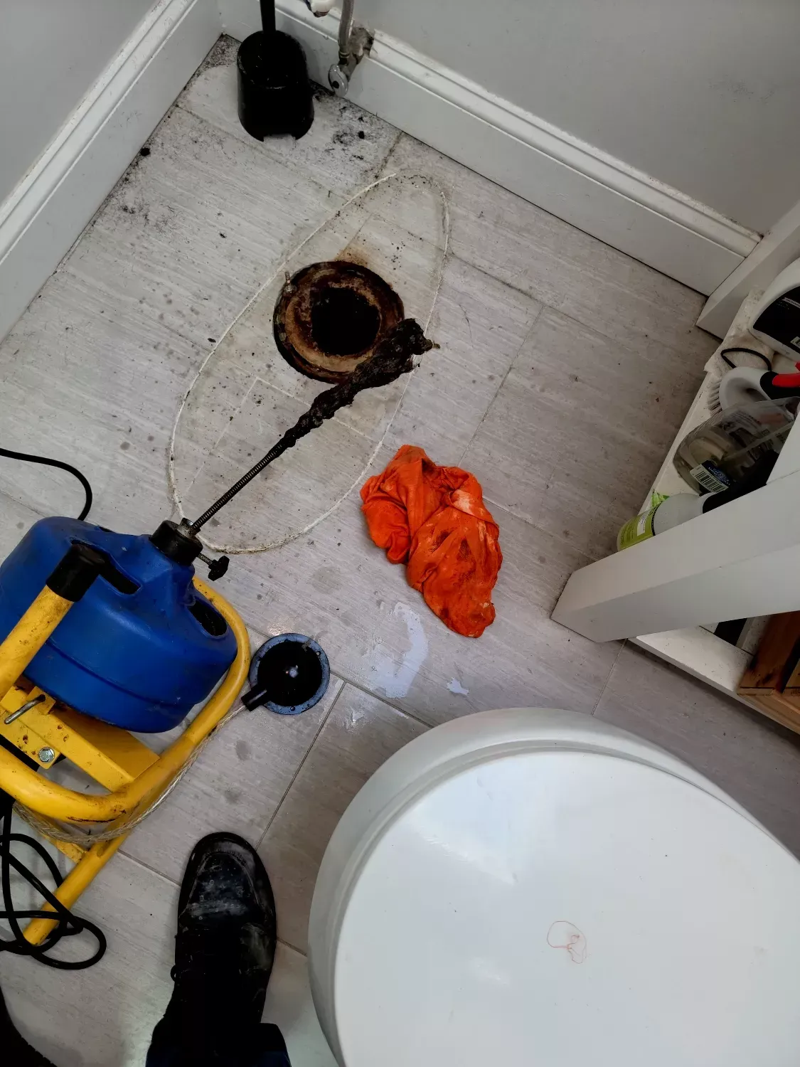A person is standing in a bathroom next to a toilet.