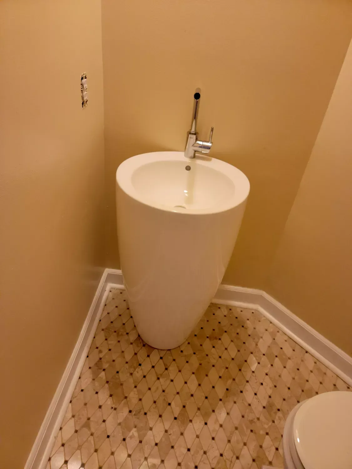 A bathroom with a pedestal sink and a toilet